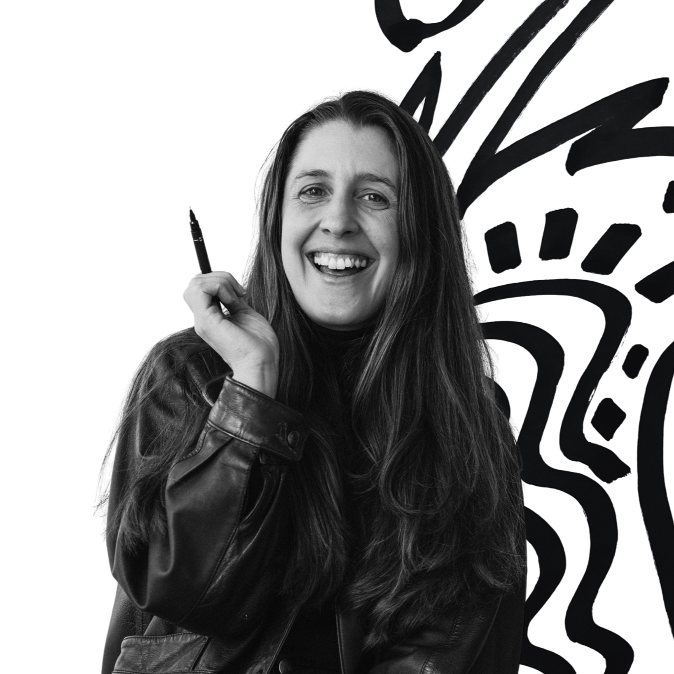 Black and white photo Kate smiling, wearing a leather jacket, holding a pen near her face, with artistic black brushstroke background.