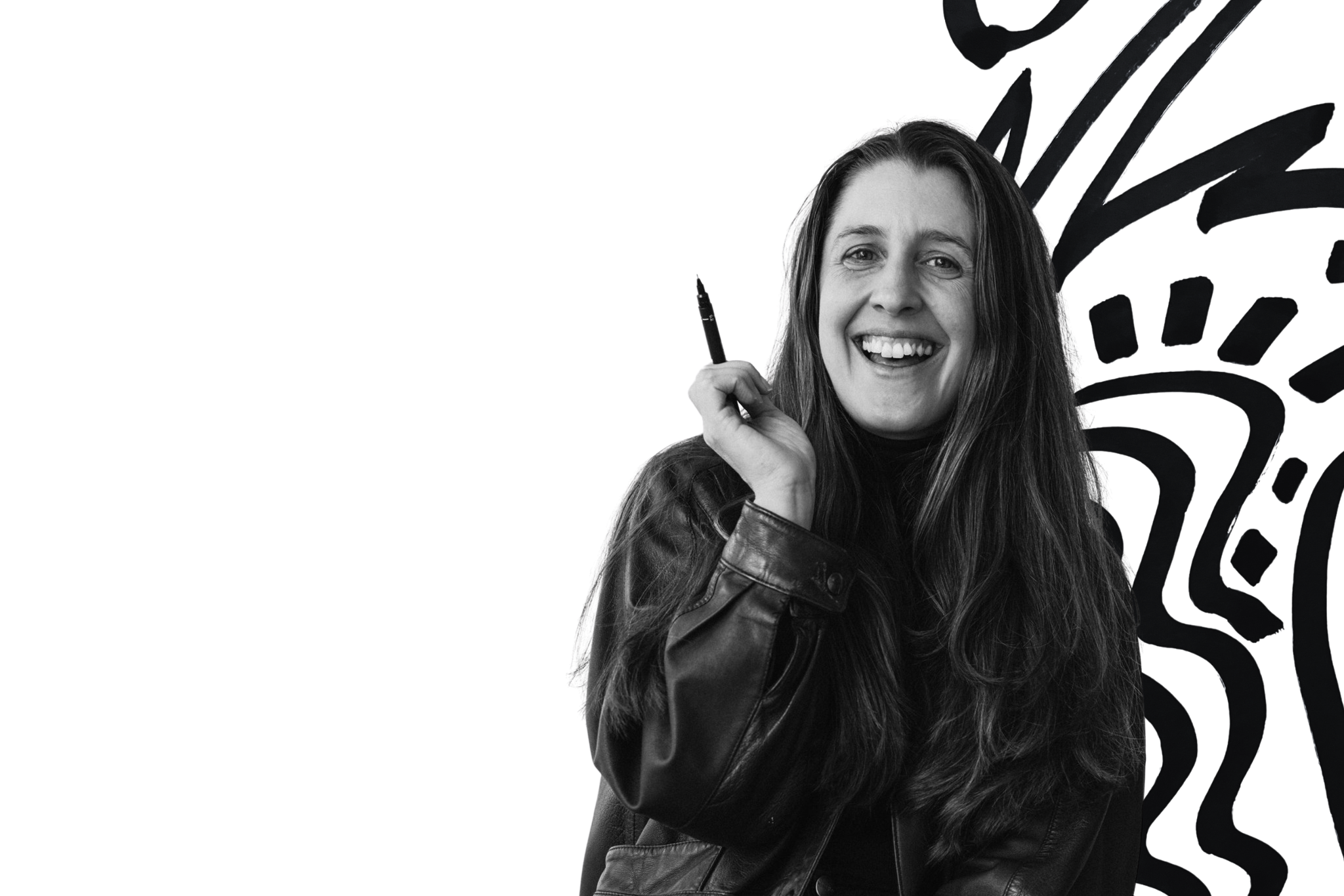 Kate smiling, wearing a black leather jacket, holding a pen, and surrounded by abstract black shapes.