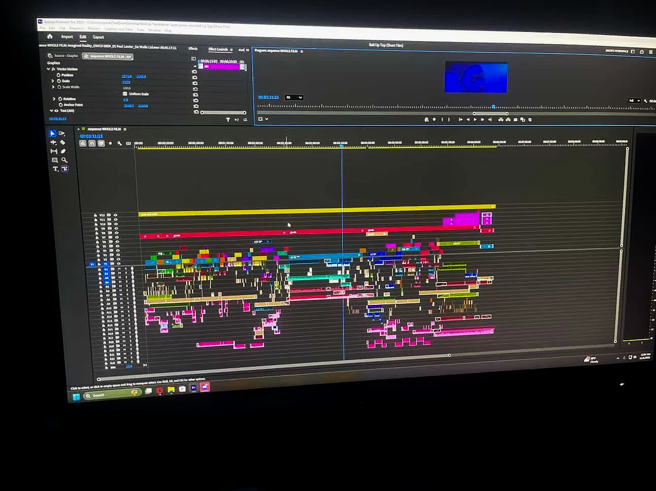 Computer screen displaying video editing software with various color-coded tracks and timeline elements.