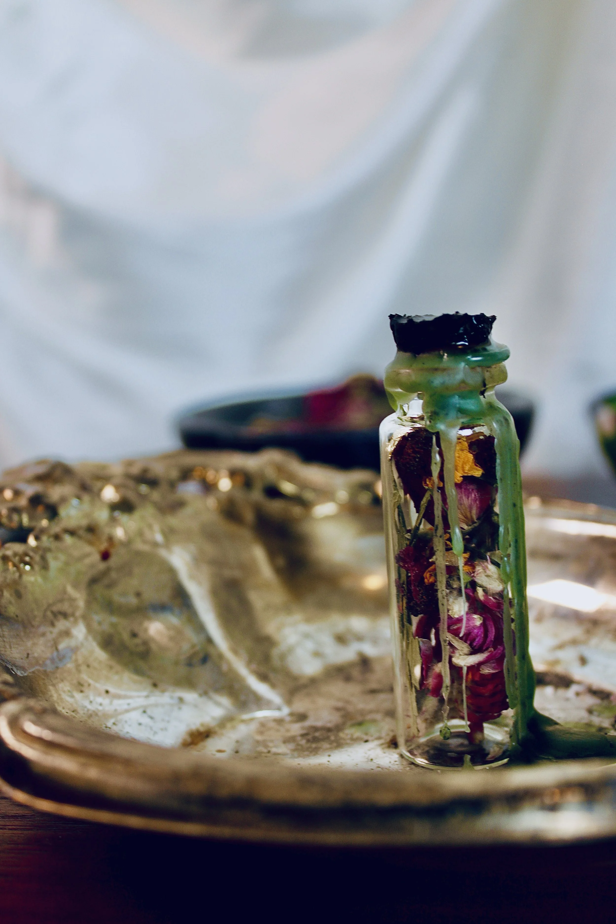 spell bottle with herbs and flowers