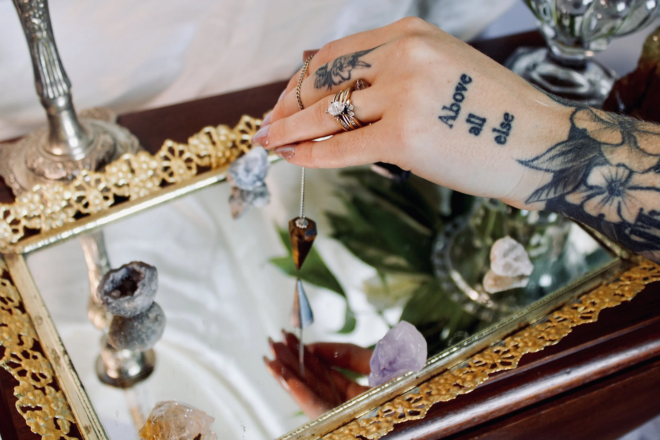 hand holding pendulum over mirror