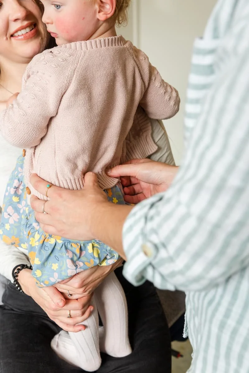 Dr Rosalind Hill assessing a young child while the child's parent provides comfort during a paediatric osteopathy appointment at Live Better Be Stronger Osteopathy & Performance in Adelaide