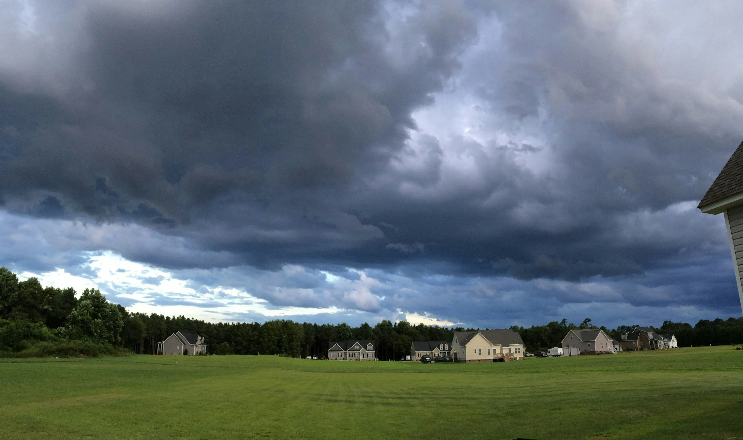 Storm clouds above neighborhood with asphalt shingle roofs