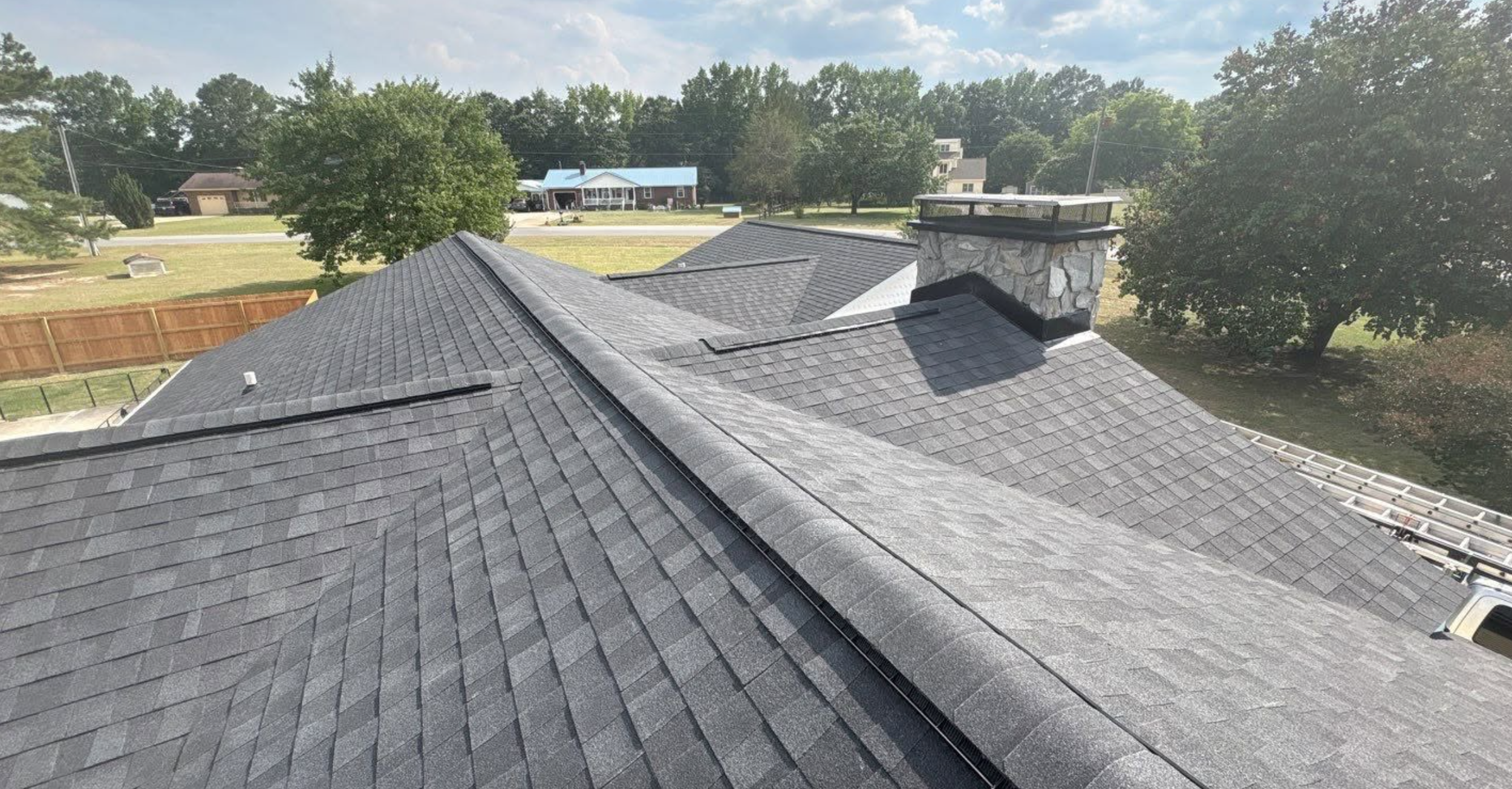 New Roof, ridge vent, gray architectural shingles, stone chimney, black flashing and chimney cap
