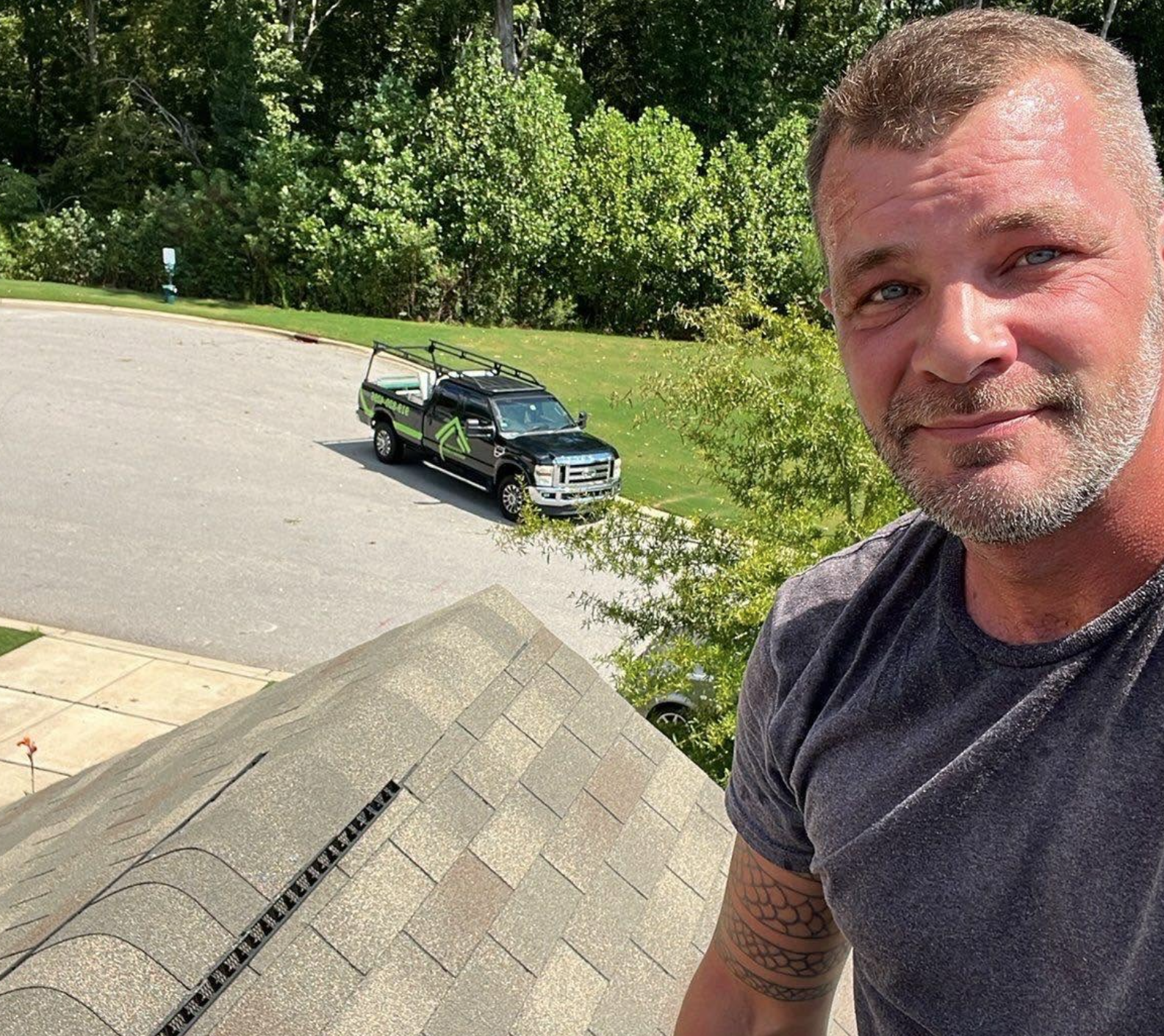 Kyle McLean Roofing and Repair Truck with Kyle on asphalt shingle roof