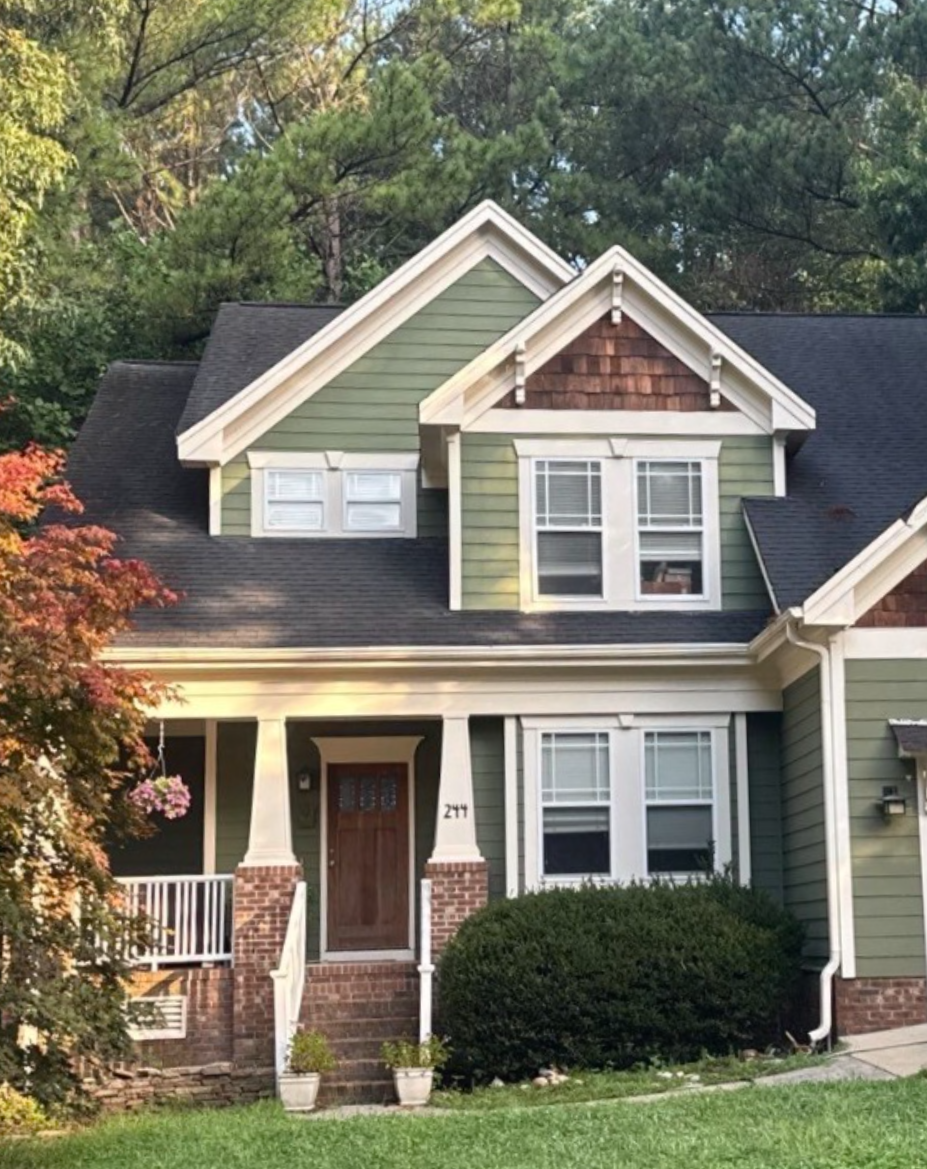 House with Green and Cedar siding, gray asphalt shingle roof, and brick accents