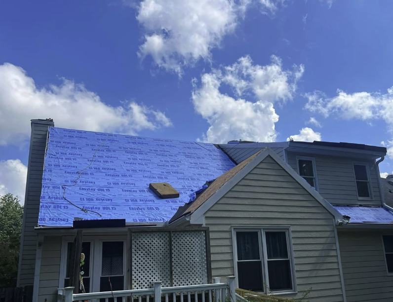Shingles torn off with underlayment showing during roof replacement