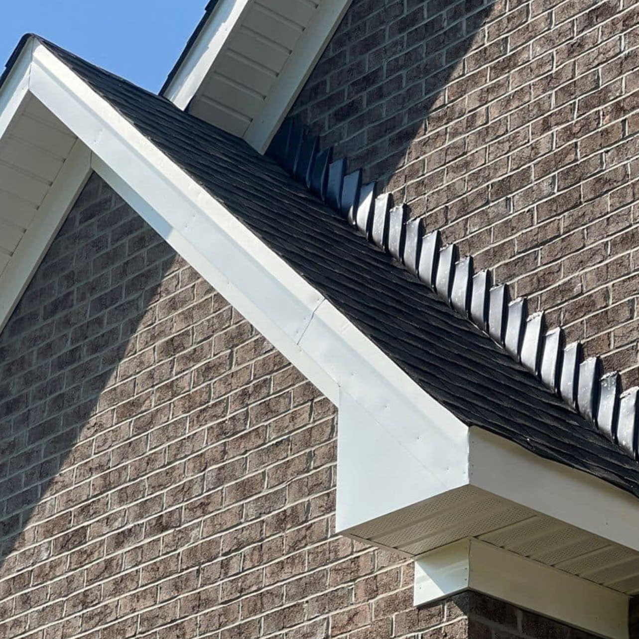 Asphalt shingle roof on brick house with repaired black flashing to stop leaks