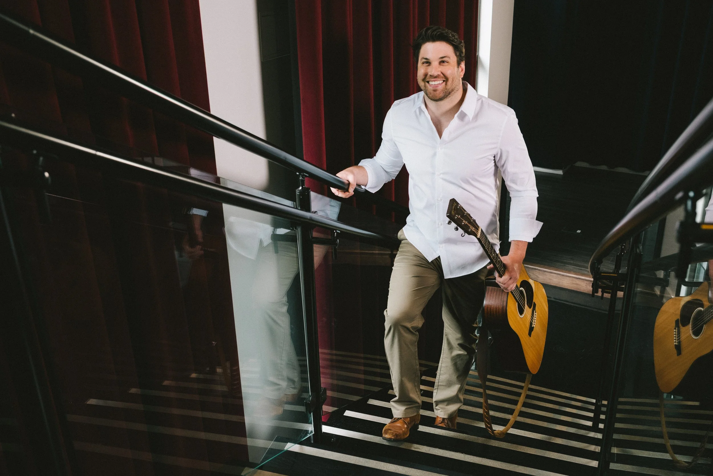 Nashville musician Lucas Alexander walking with his acoustic guitar