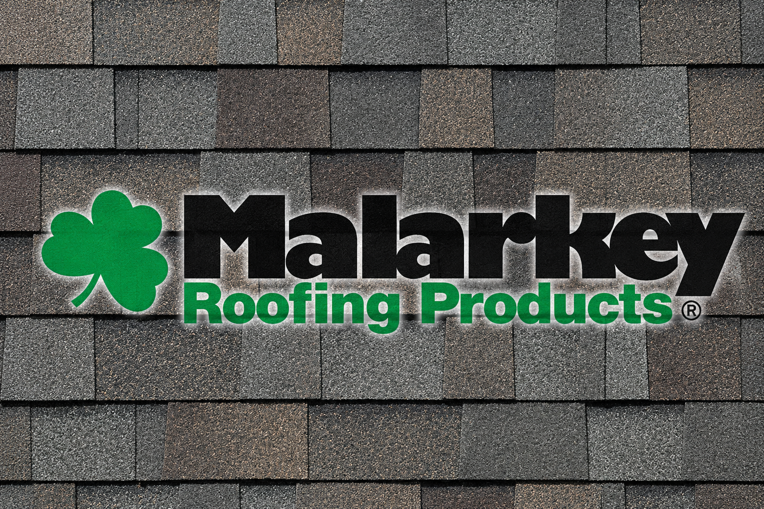 Sign with a green three-leaf clover and the text 'Malarkey Roofing Products' in black and green, mounted on a shingled wall.