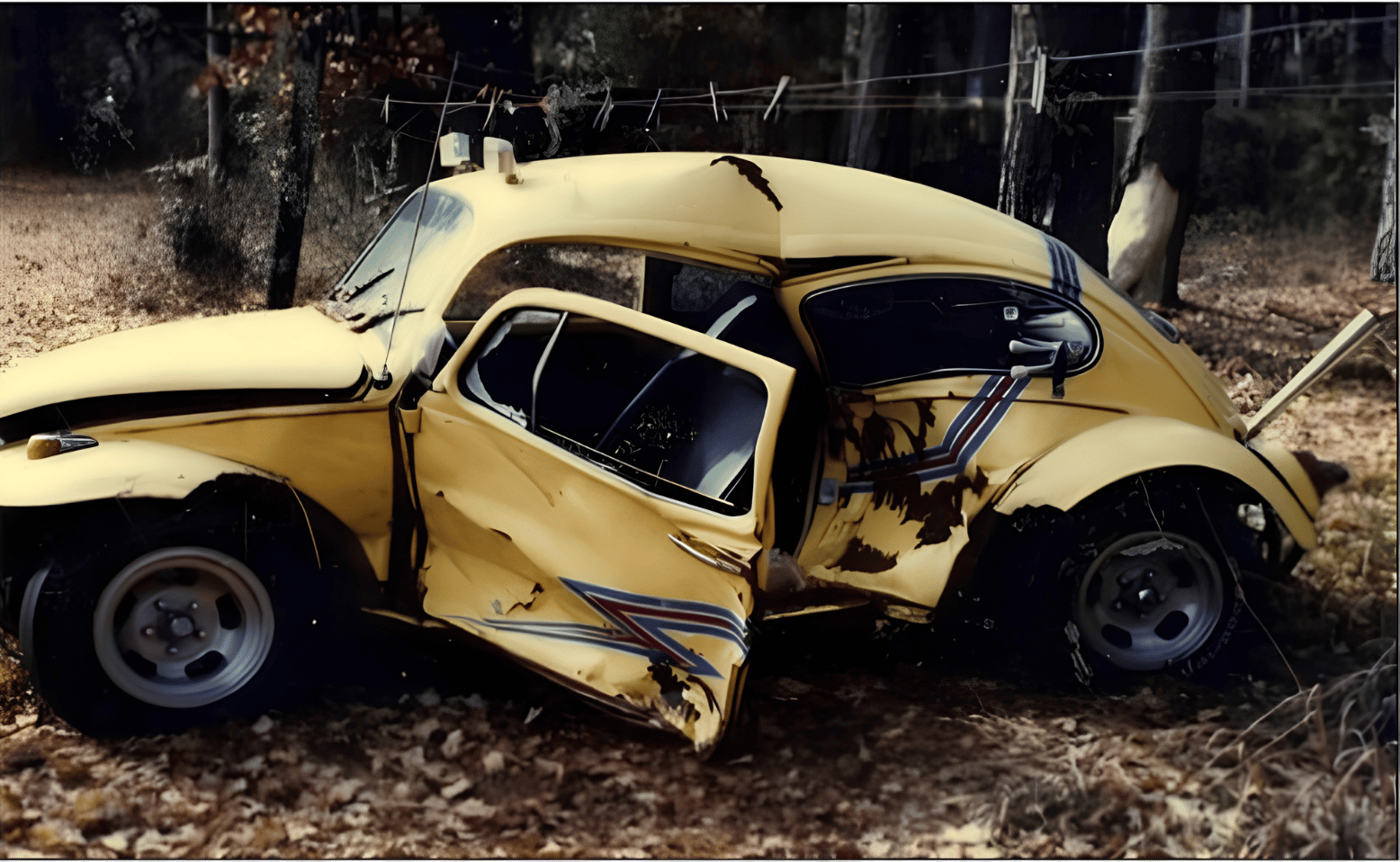 Michael J. Bowen's yellow vintage car with extensive damage, including a crumpled door and missing wheels after the car crash accident.