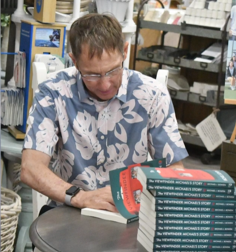 Michael J. Bowen signing a book in a book signing event.