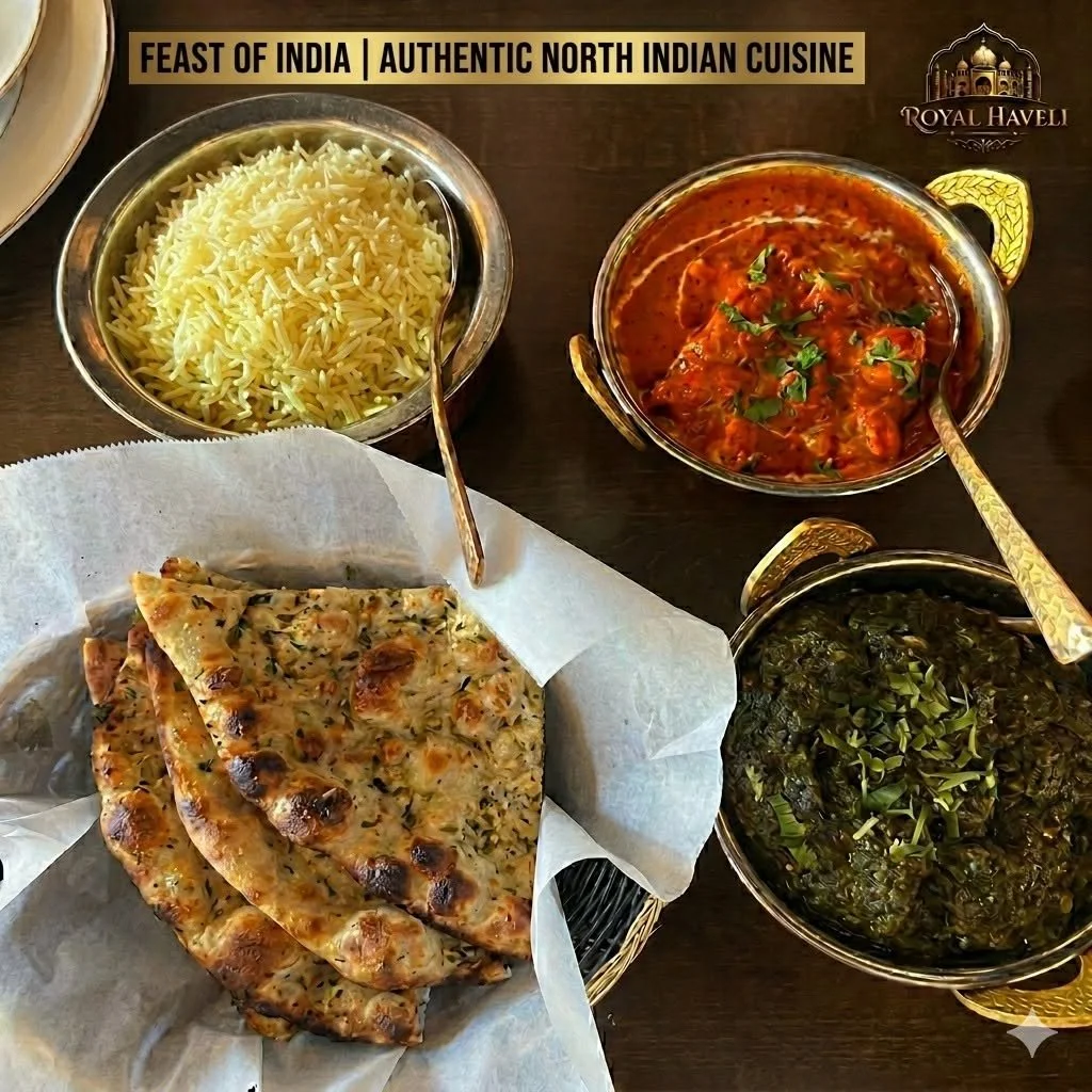 Indian feast featuring a bowl of yellow basmati rice, a bowl of red curry garnished with green herbs, a bowl of cooked greens, and flatbread with herbs on white parchment paper.