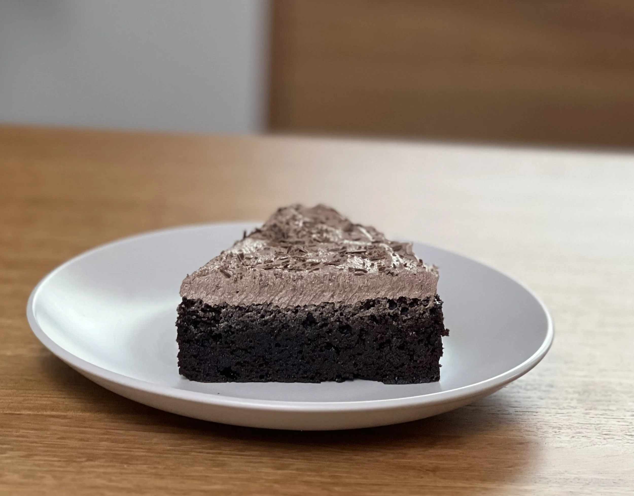 Slice of Gluten-Free Chocolate Mud Cake topped with fluffy Chocolate Buttercream