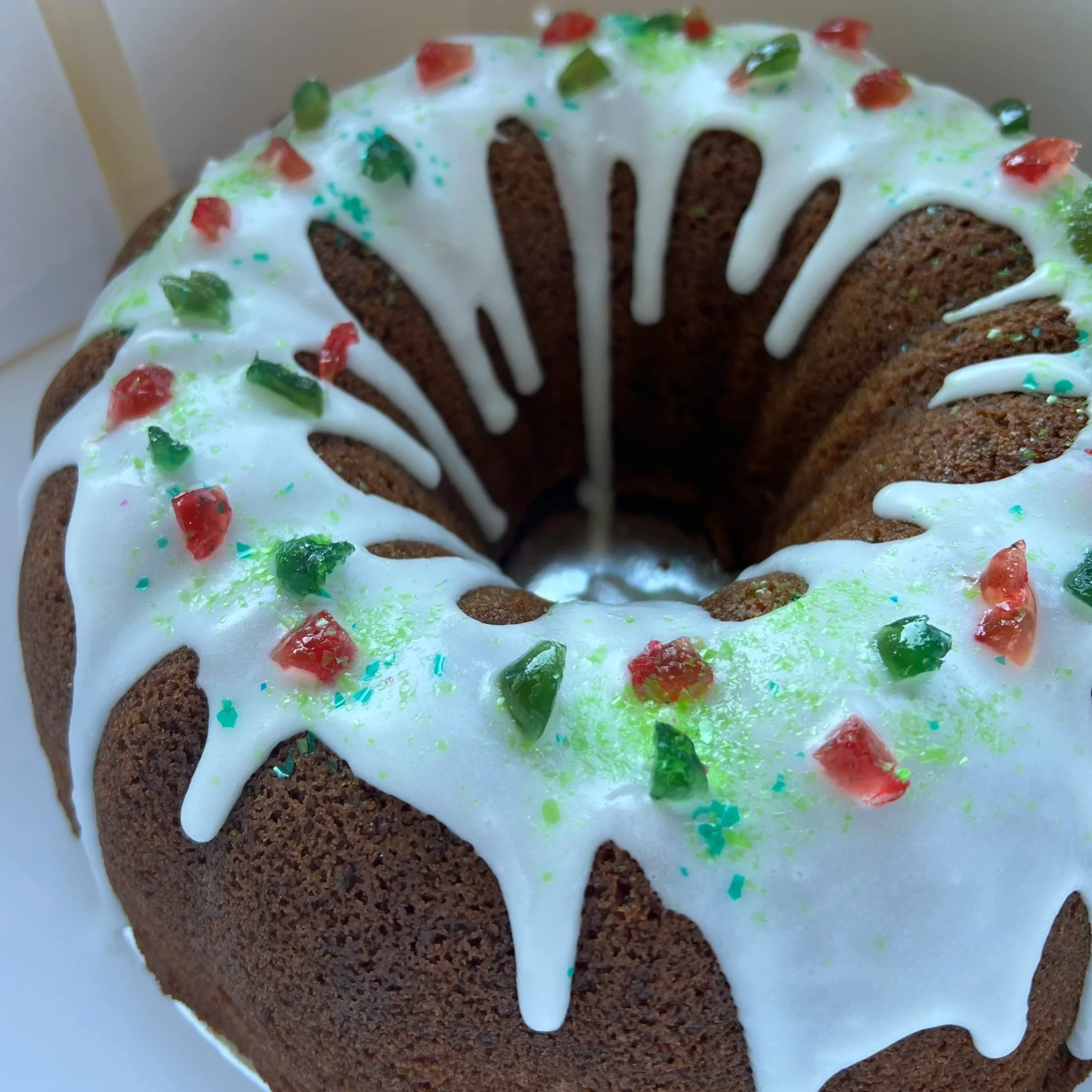 Gluten-Free Cranberry Almond Bundt Cake iced and topped with Glacé Cherries