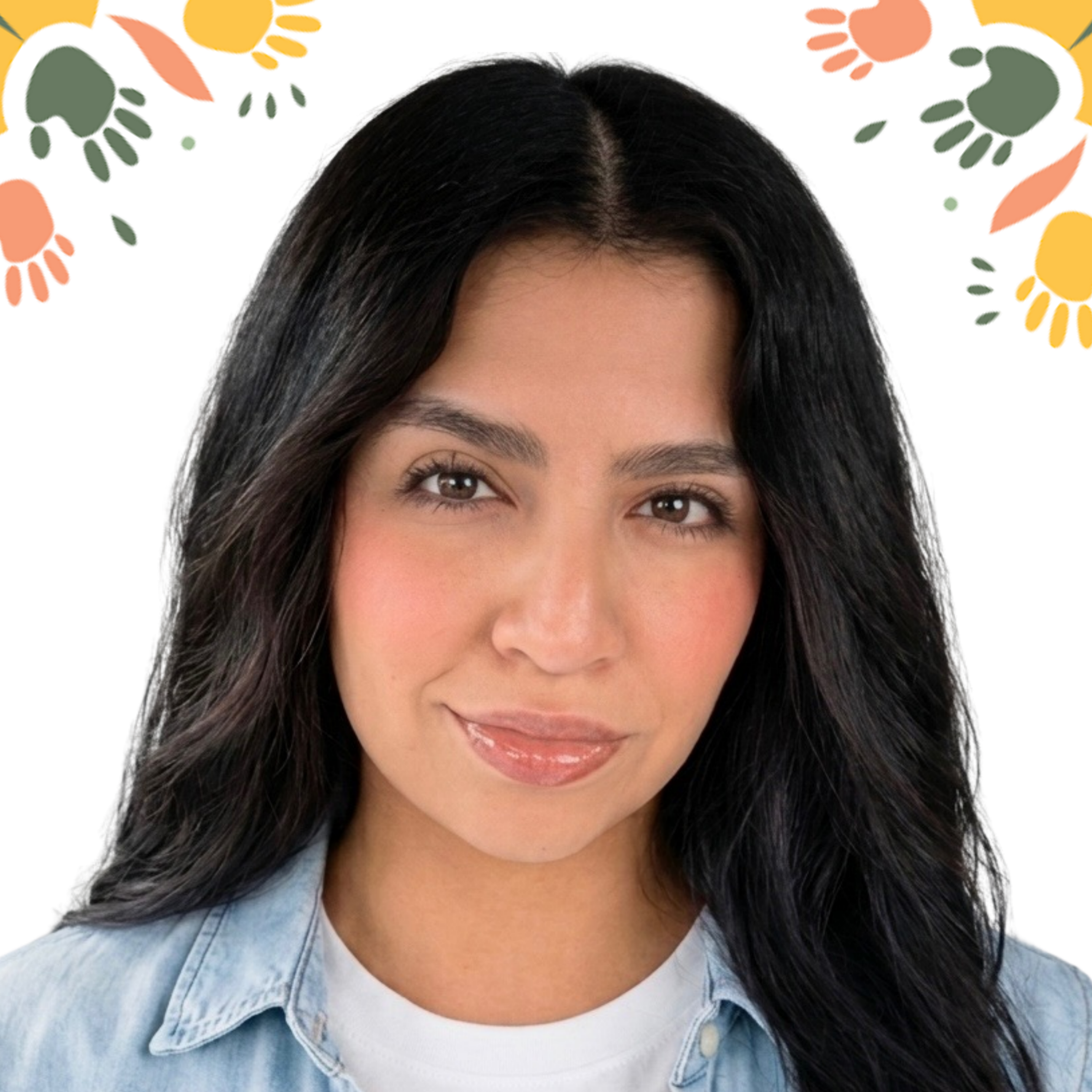 Close-up of a woman's face showing her eyes, nose, and lips. She has dark, wavy hair and is wearing a light blue denim shirt over a white top. The background is decorated with colorful, abstract handprints in orange, green, and yellow.
