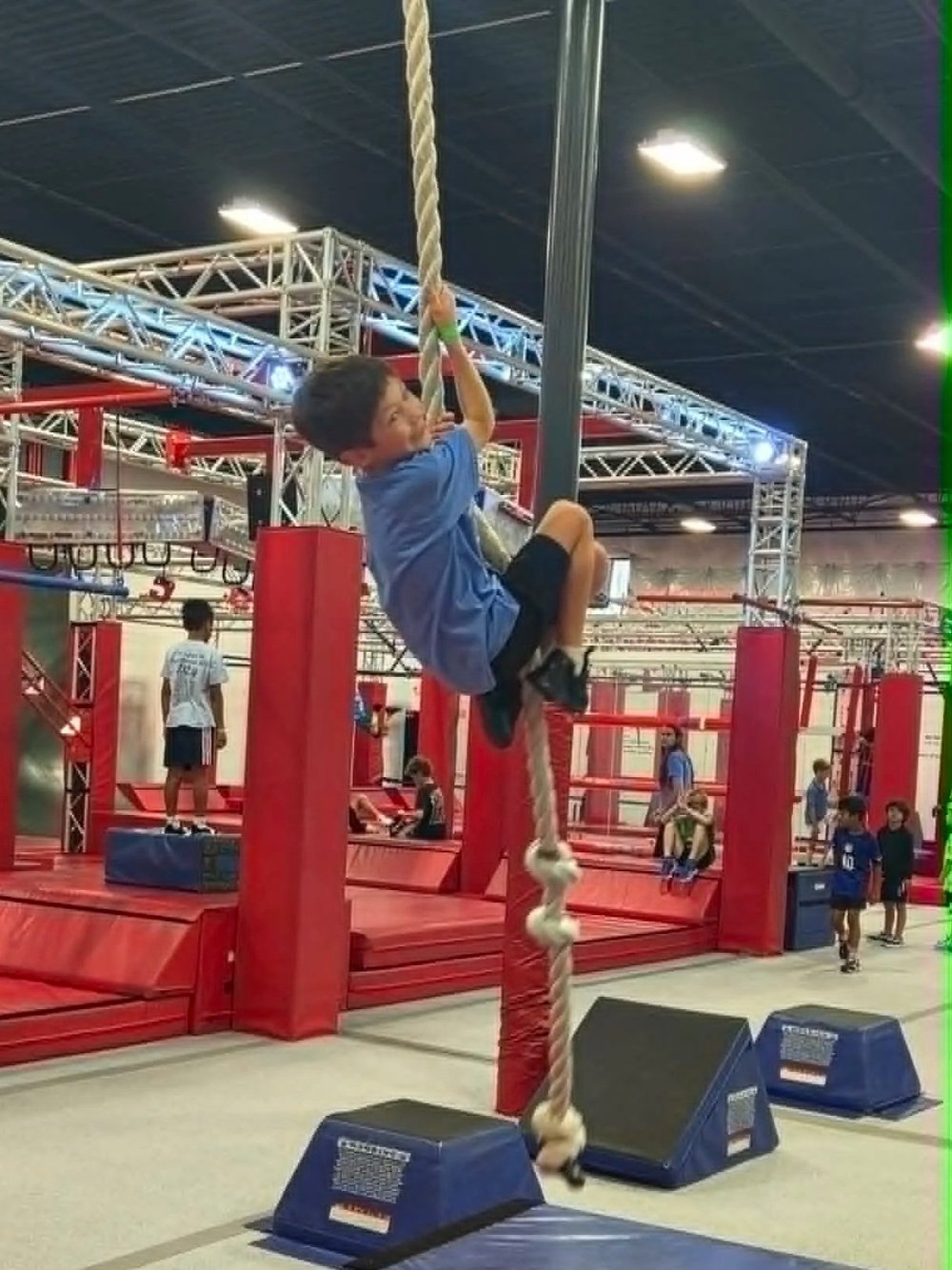 Child climbing a rope during ninja training at Octo Ninja