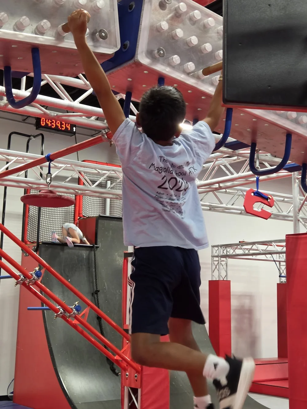Young ninja athlete practicing an overhead obstacle at Octo Ninja