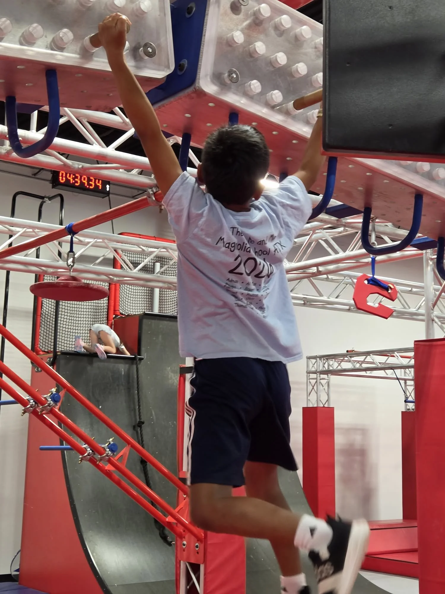 Young athlete practicing grip and climbing skills at an indoor ninja gym