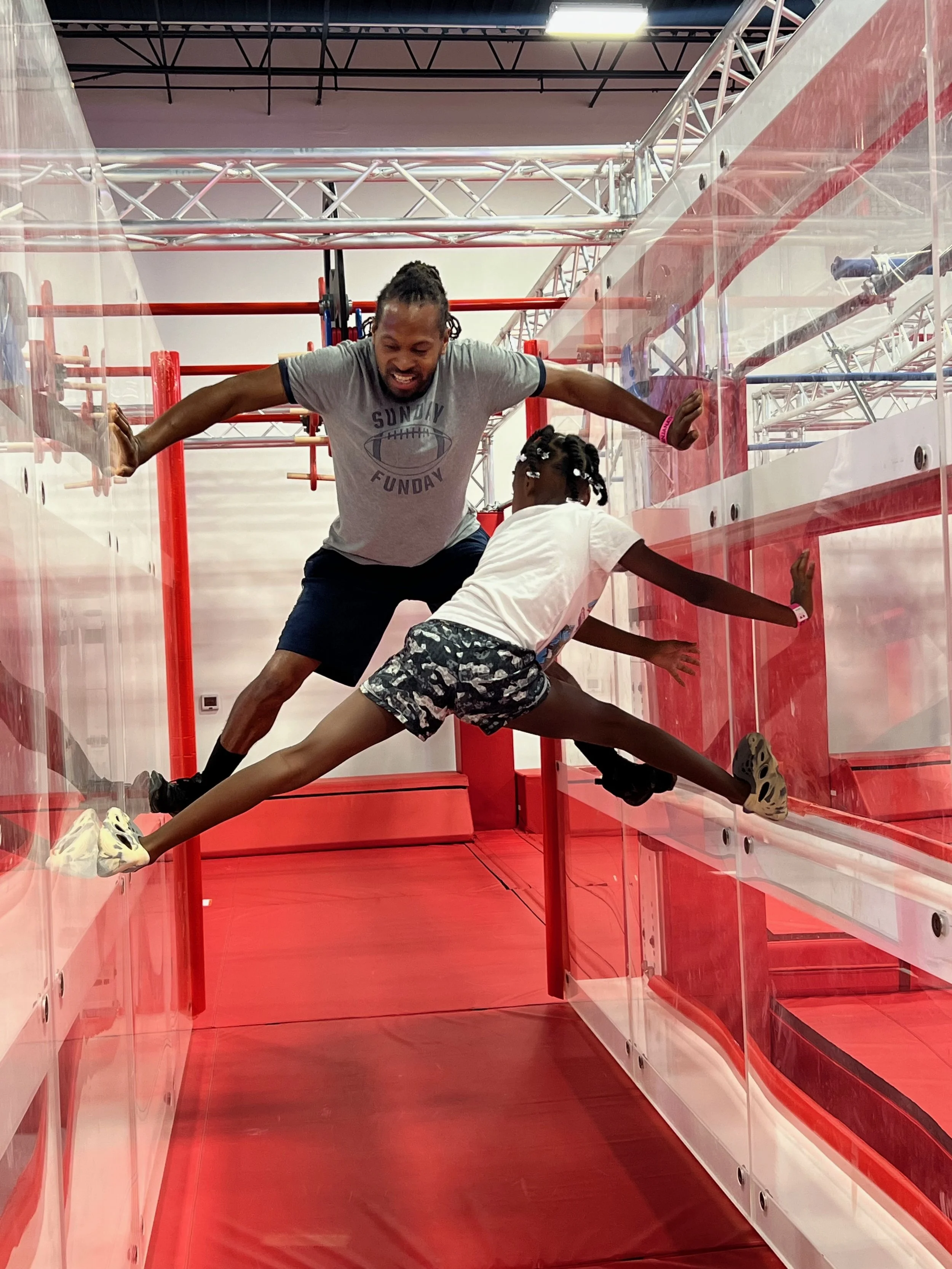 Father and daughter jumping between the Spider Walls at Octo Ninja in Austin