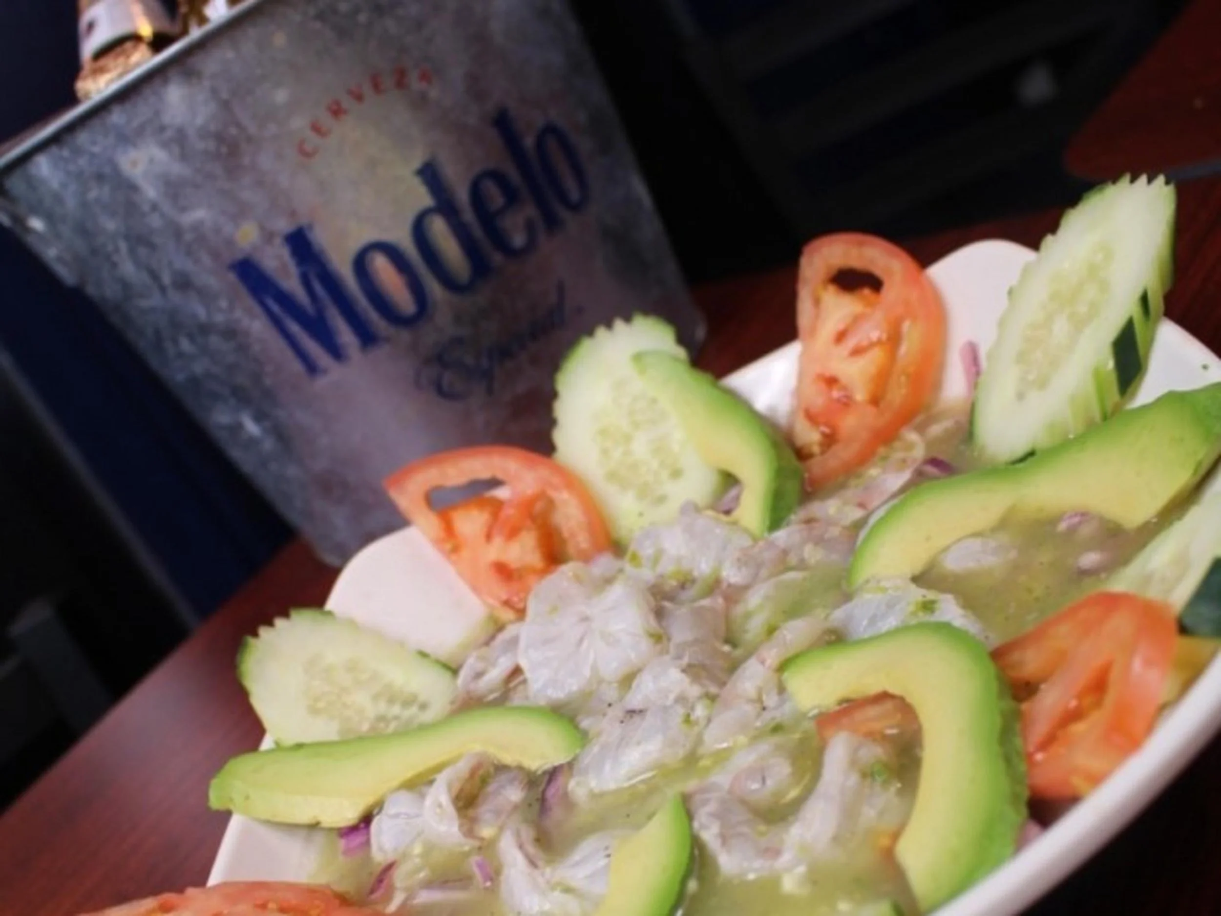Close-up of a seafood platter featuring lobster, shrimp, crab, and sliced vegetables such as cucumber and tomatoes.