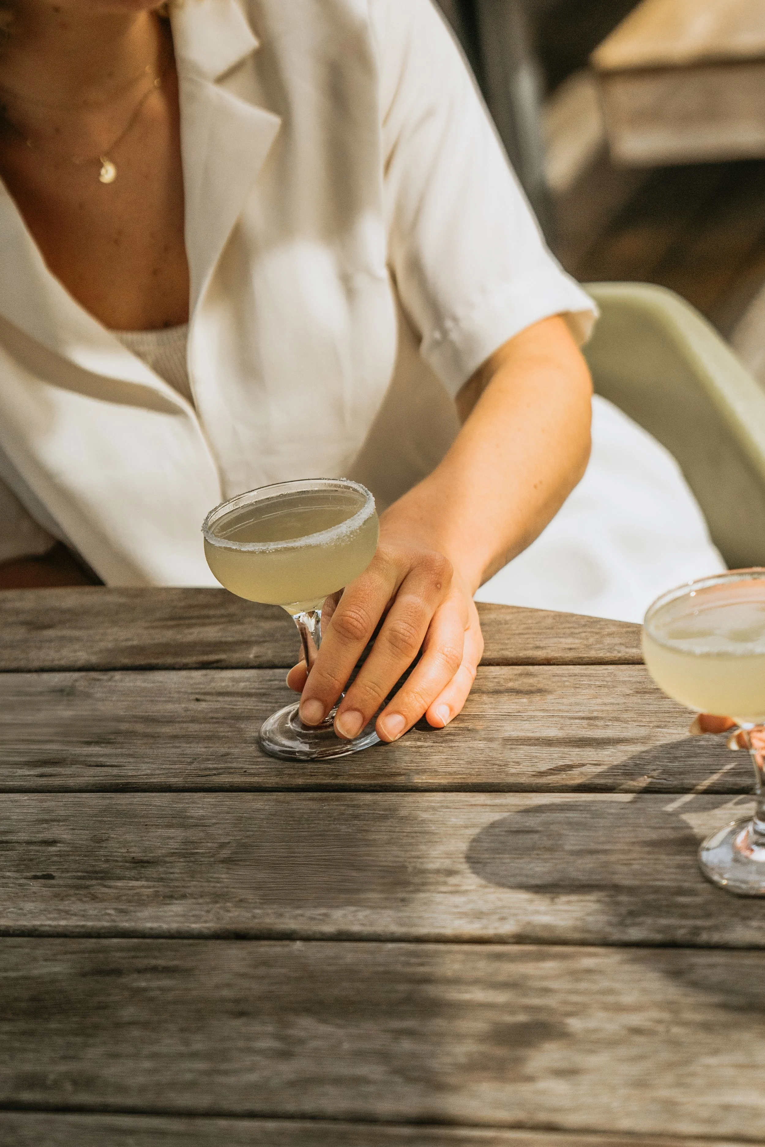 Female outside, enjoying a margarita. 