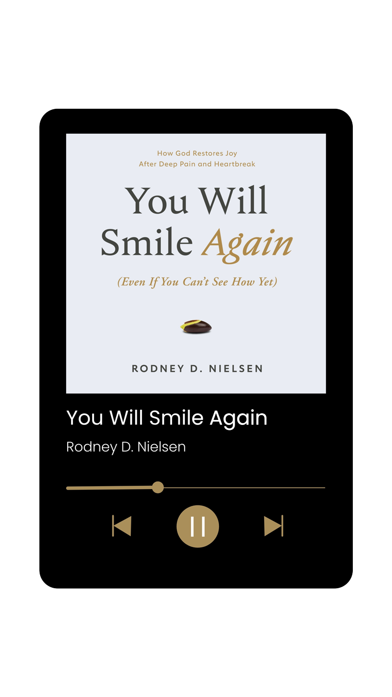 Audiobook book in mp3 player: 'You Will Smile Again (Even If You Can't See How Yet)' by author and pastor Rodney D. Nielsen. Subtitle: How God Restores Joy After Deep Pain and Heartbreak. Cover is white except for a small seed beginning to grow.