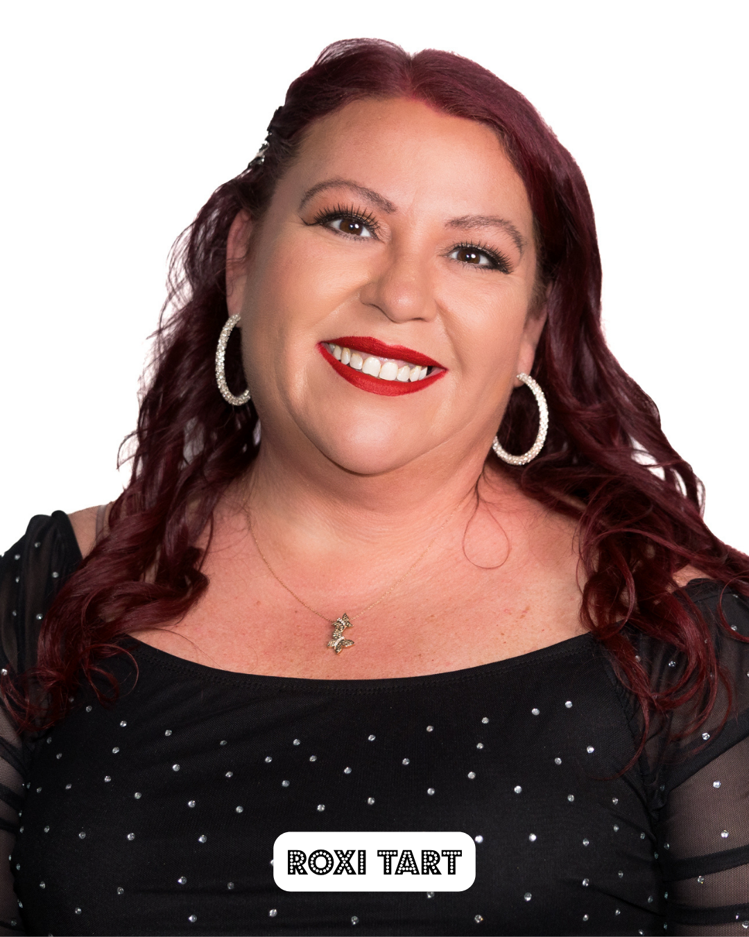 Headshot of a woman with red hair, wearing hoop earrings and a necklace, smiling, with the name 'Roxi Tart' written at the bottom.