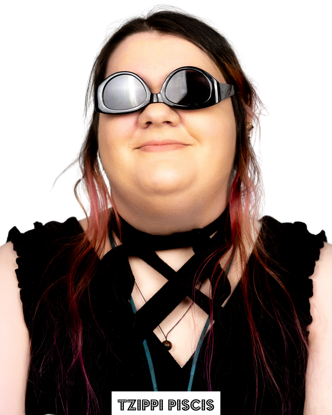 Portrait of a smiling person wearing swimming goggles and a black outfit with crisscross straps, with the name 'Tzippi Piscis' at the bottom.