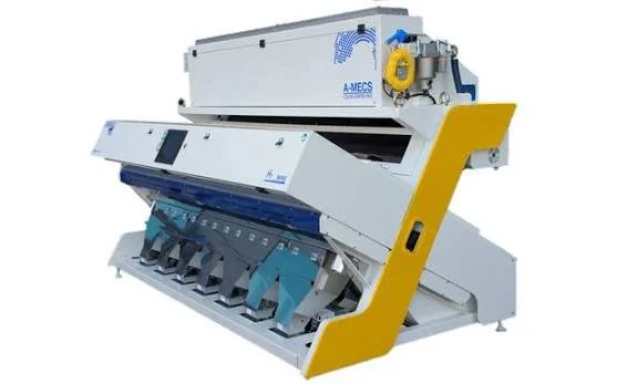 A large industrial machine with a white body, blue and yellow accents, and multiple compartments, used for manufacturing or processing.