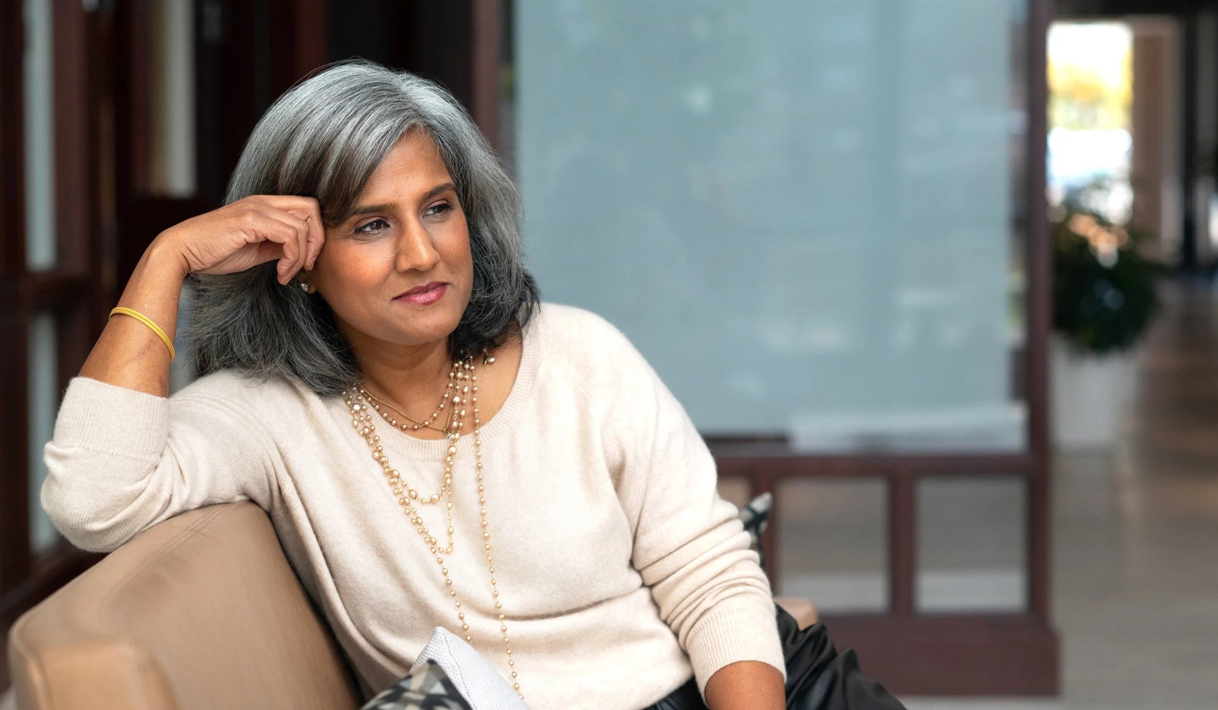 Headshot of Latha Rao, fractional COO and founder of Clear to Scale, sitting on a couch