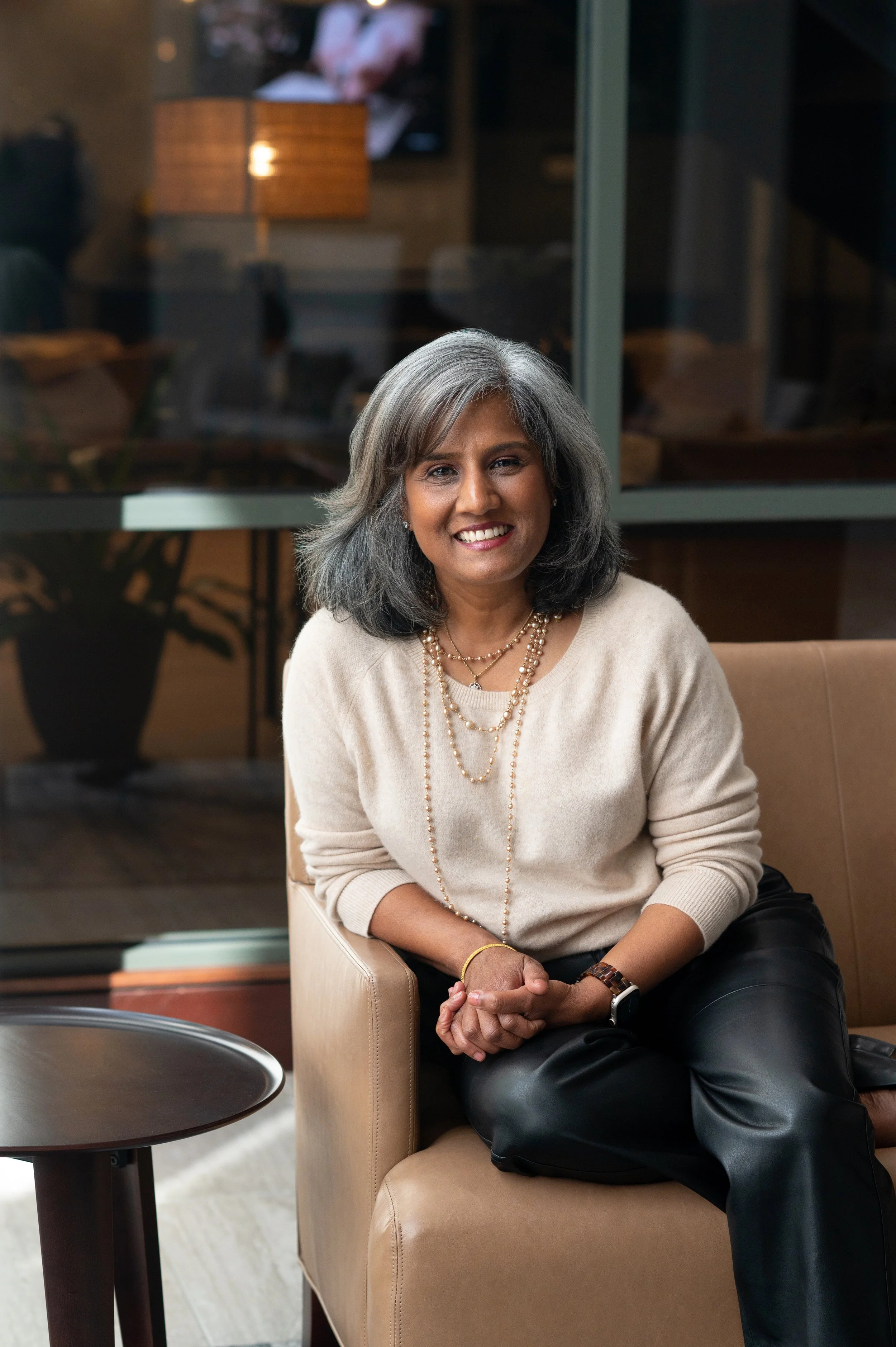 Latha Rao, fractional COO for wellness practices, smiling on a couch