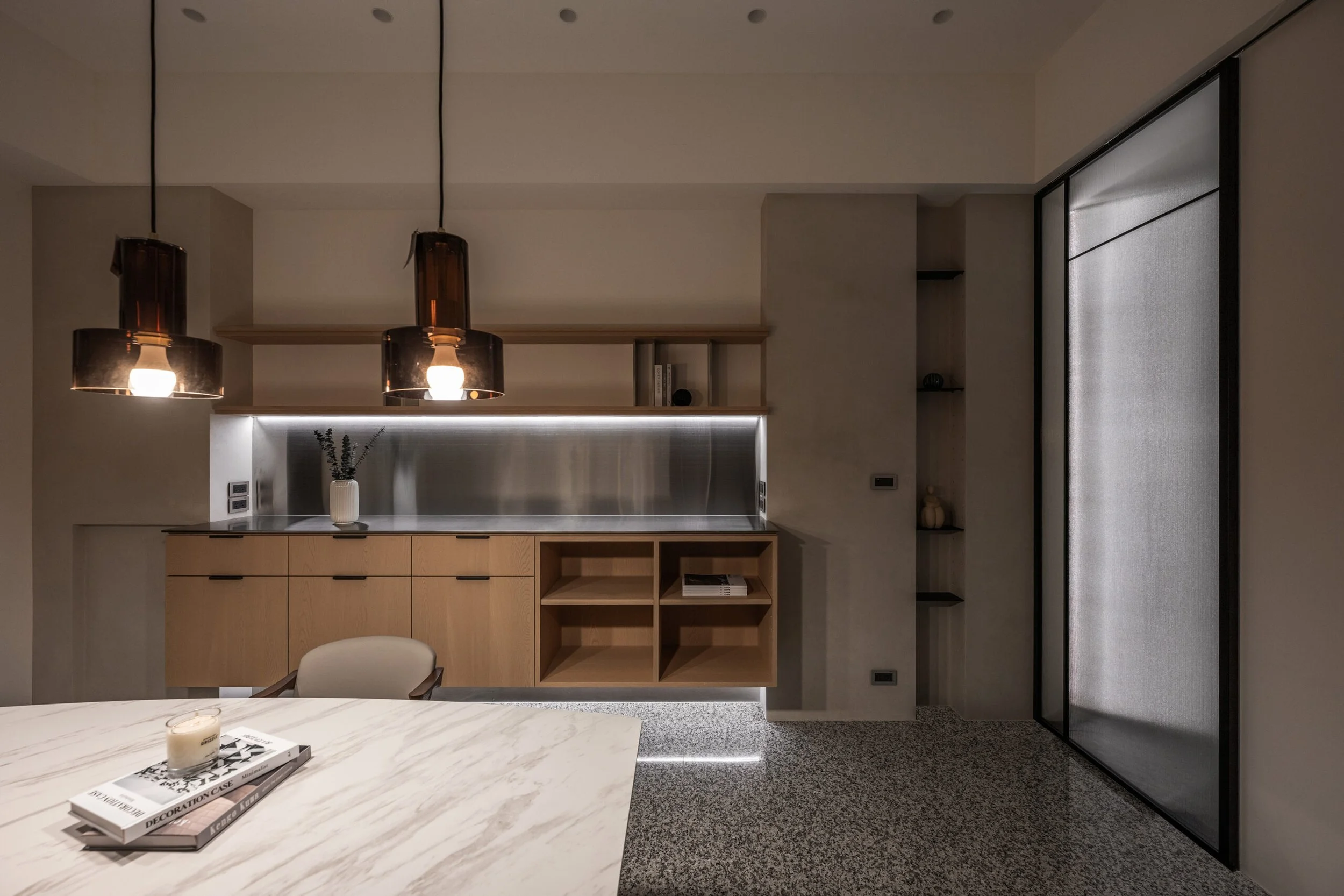 Modern kitchen with hanging pendant lights, wooden cabinets, open shelving, and a gray granite floor.