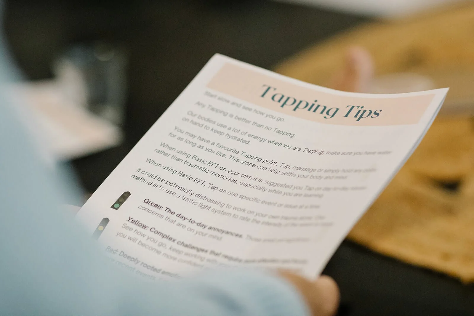 A person holding a printed sheet titled 'Tapping Tips' with tips and illustrations about tap water. The sheet includes sections about different tap water colors and their meanings.