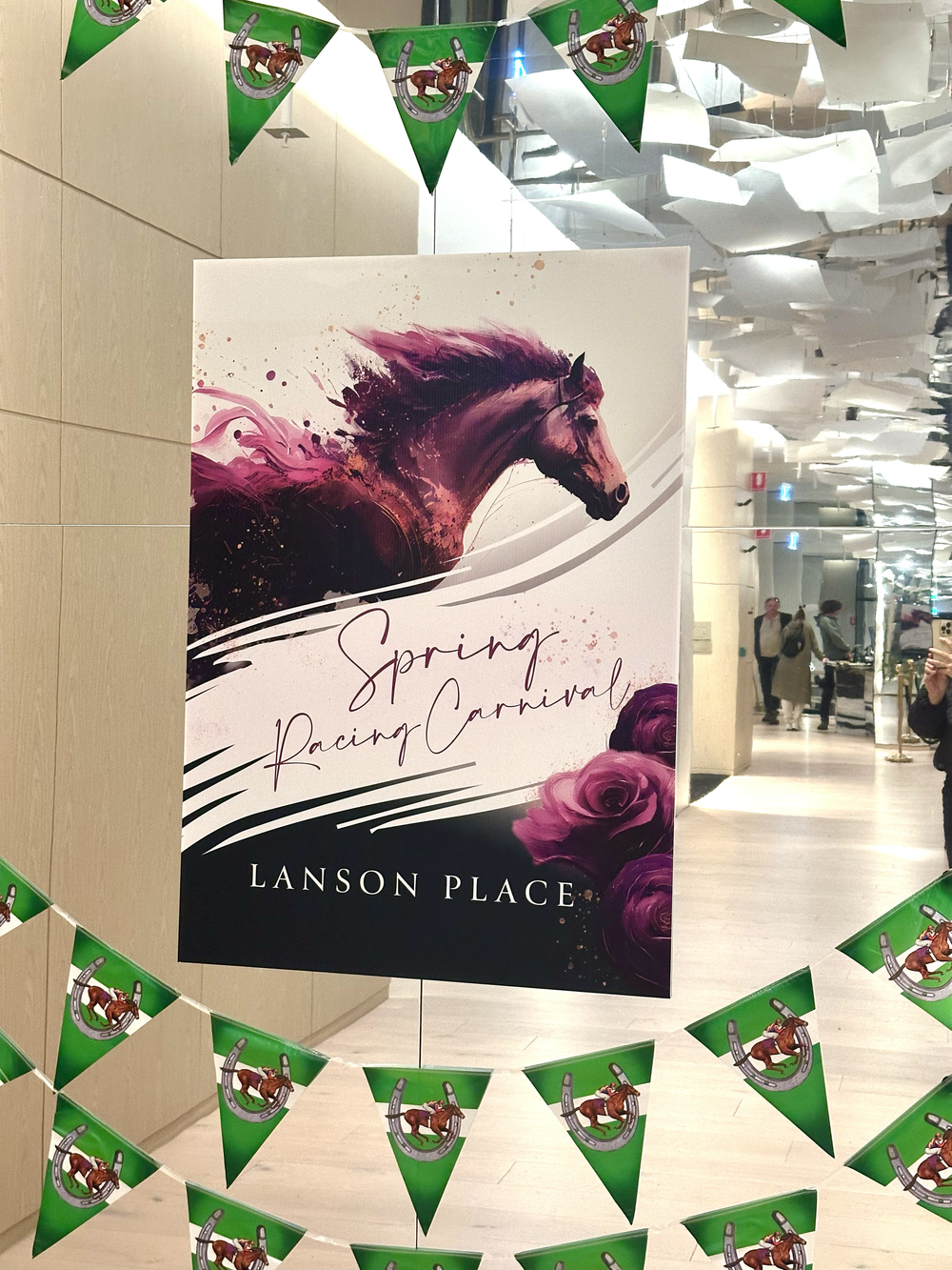 Poster advertising a Spring Racing Carnival at Lanson Place, featuring an artistic depiction of a horse's head in purple and pink hues with roses and decorative text.