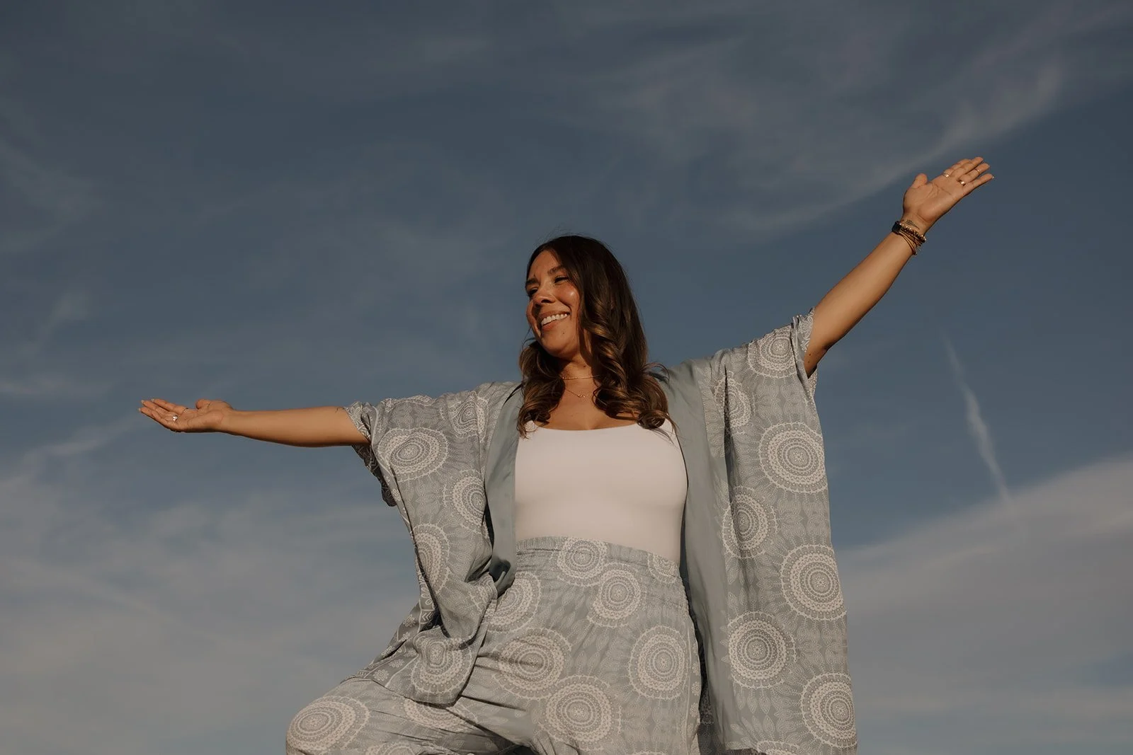 Trauma therapist standing outdoors with open arms, symbolizing healing, emotional growth, and taking the first step toward EMDR therapy and counseling.