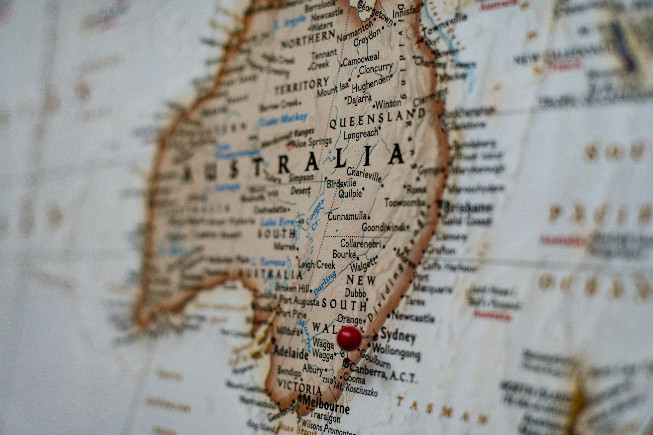 Close-up view of a map showing the country of Australia, with emphasis on its eastern coast, including states like Queensland and New South Wales, and cities like Brisbane, Sydney, and Melbourne, with a red pin marker over Sydney.