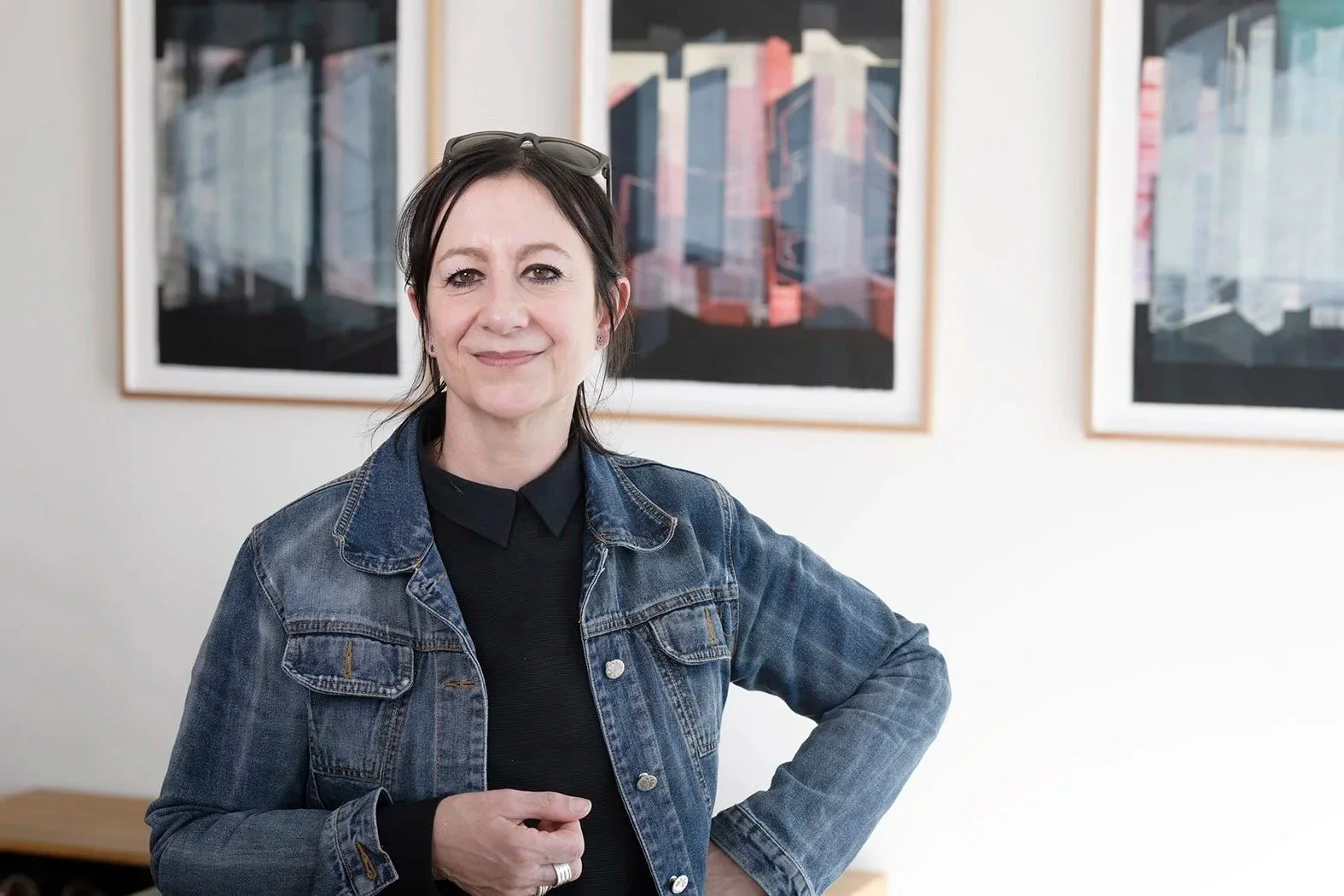 Printmaker Cat Poljski standing in front of her framed prints