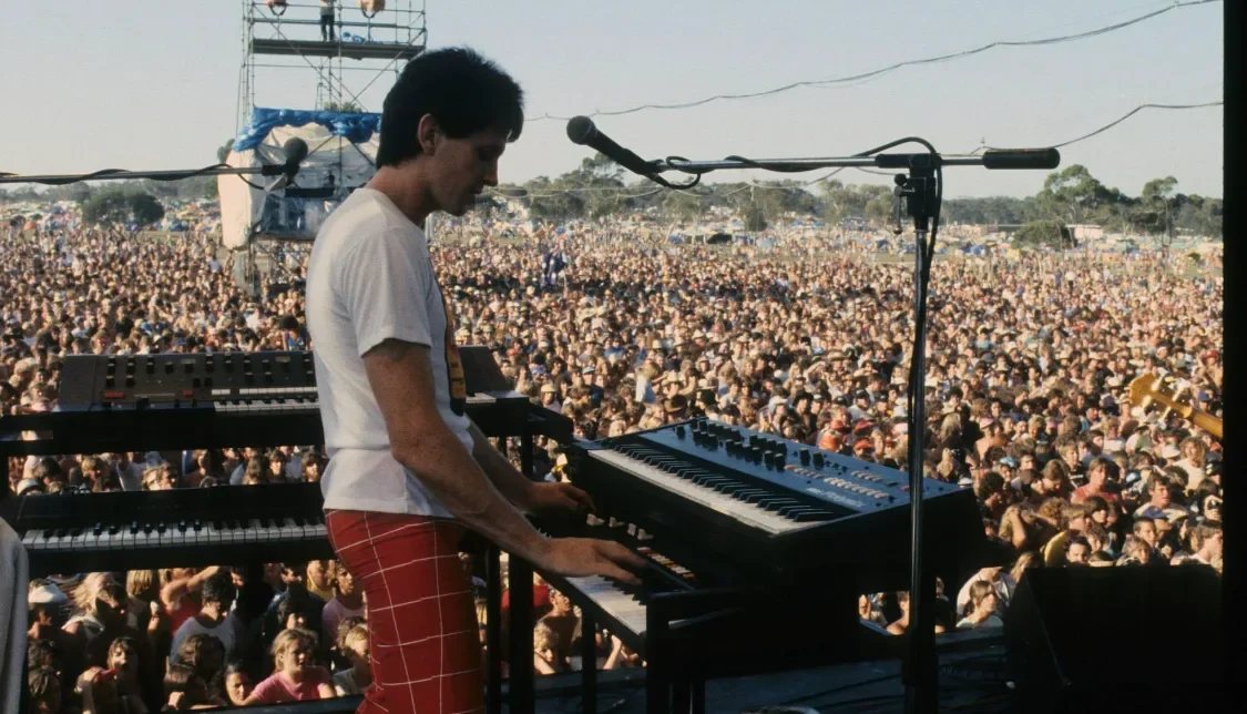 Brendan Callinan on keyboards with the Radiators in front of a large crowd, Narara 1983.