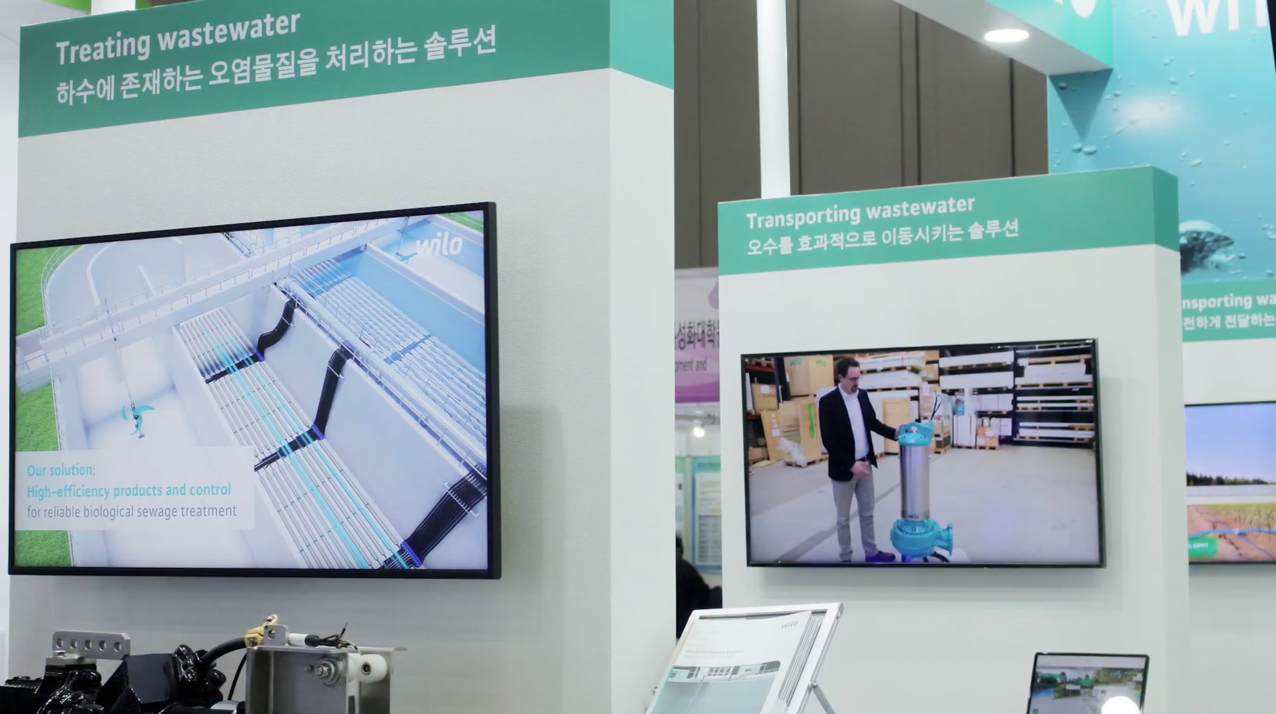 폐수 처리와 운송 솔루션을 설명하는 전시 부스 모습, 두 디스플레이에 관련 정보와 이미지가 표시되어 있음.