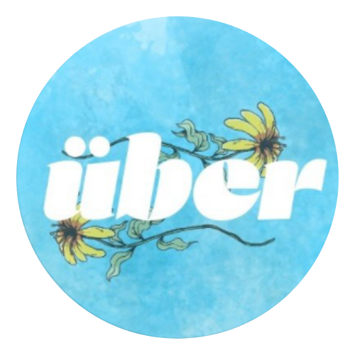 하늘색 배경에 흰색 글씨로 'über'가 적혀 있고, 노란색 꽃과 초록색 잎이 장식된 로고.