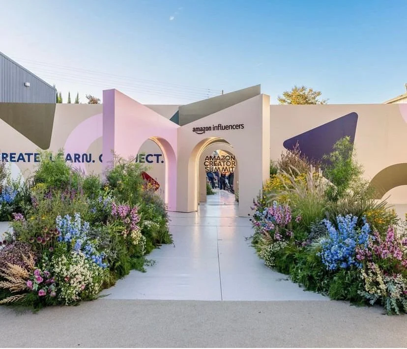 Entrance to the Amazon Influencers Amazon Creator Summit with colorful flowers and geometric wall designs.
