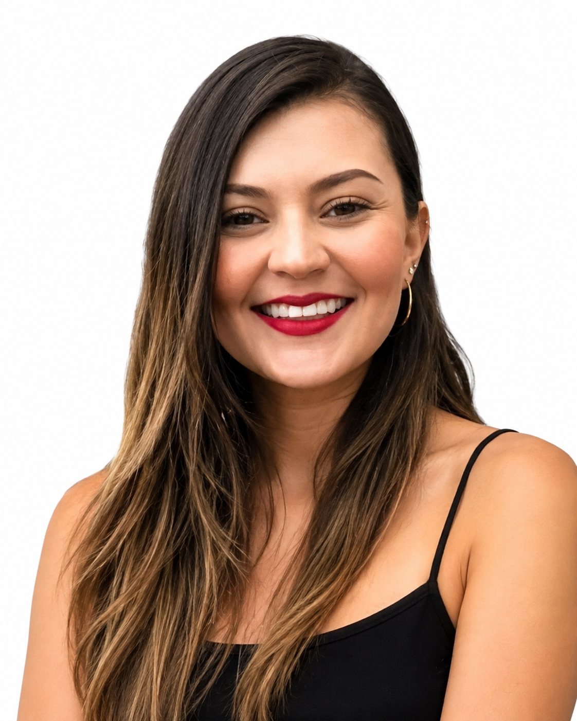 A young woman with long brown hair, wearing a black spaghetti strap top, smiling with red lipstick, earrings, and a natural makeup look, posed against a plain white background.