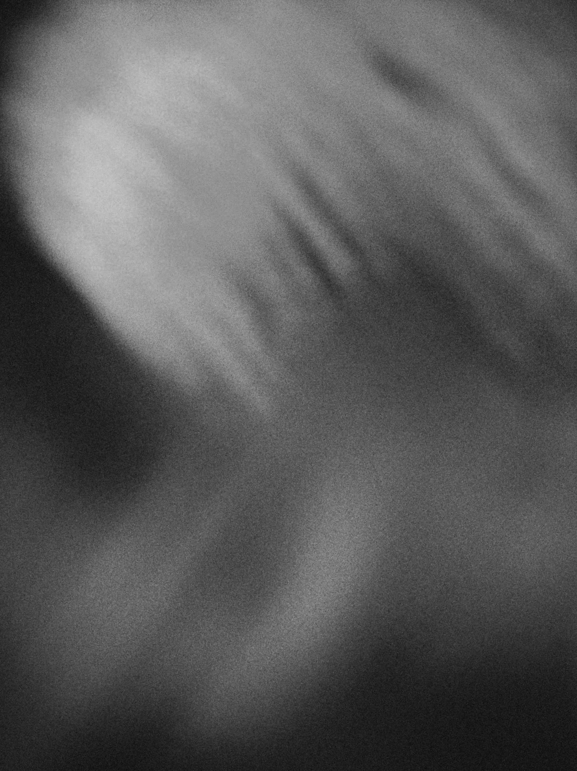 Photo en noir et blanc d'une surface texturée avec dégradés de lumière et ombres.