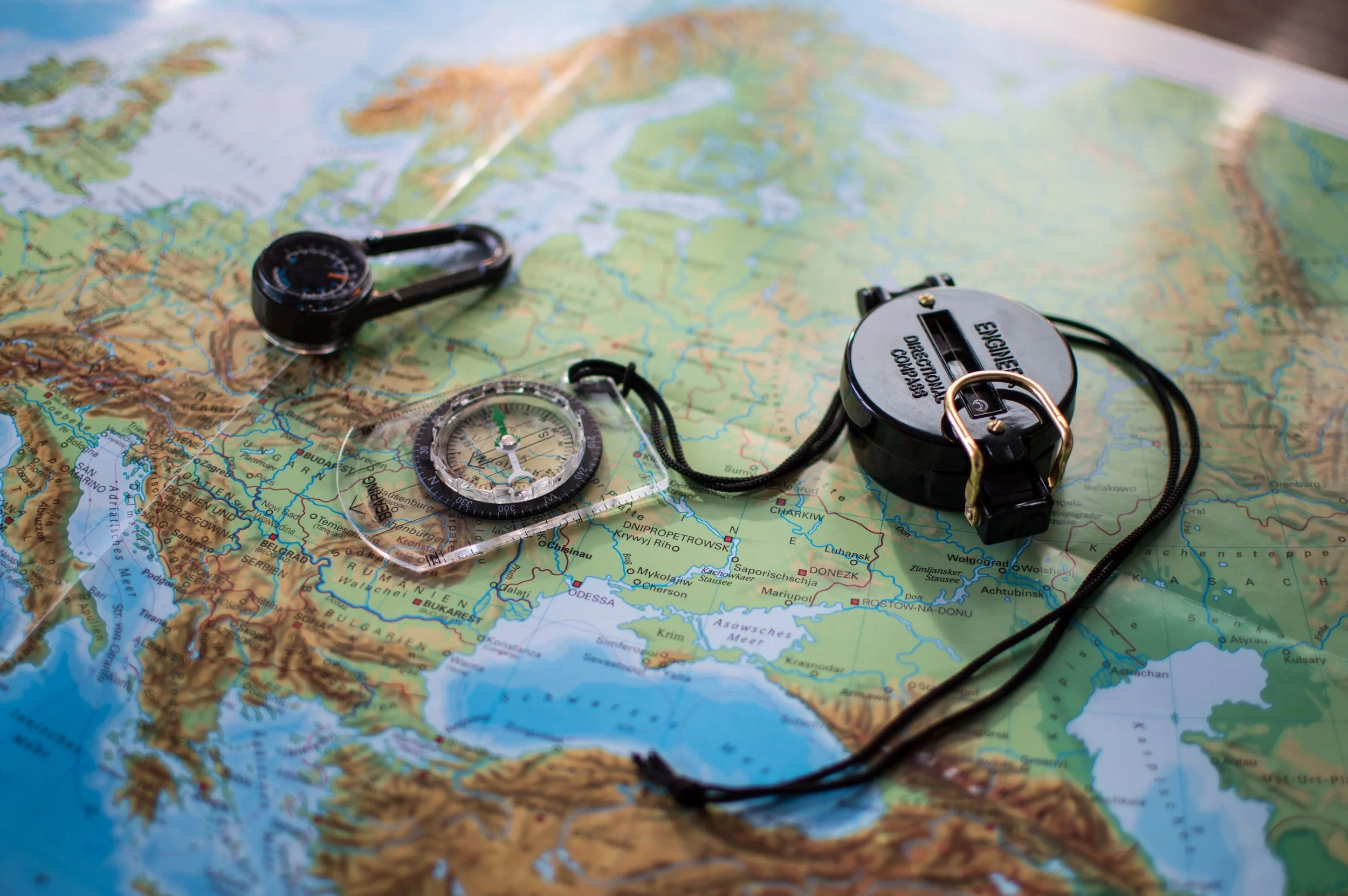 A compass and navigation tools rest on a detailed map, representing outdoor adventures made possible through financial aid for summer camp, summer camp assistance, and help paying for summer camp.