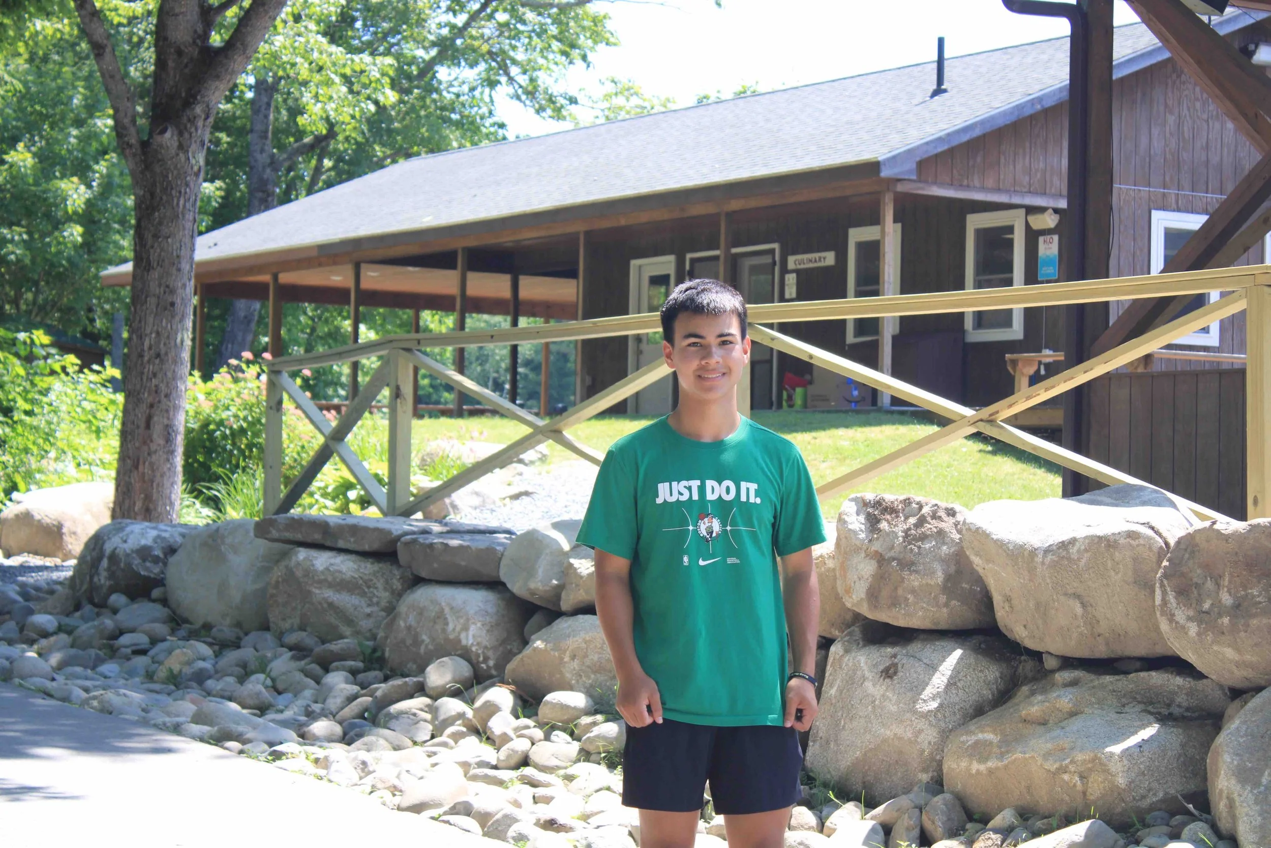 Founder, David Robinson, stands outside a summer camp cabin, supporting programs that promote skill development for children and expand access to life-changing camp experiences.