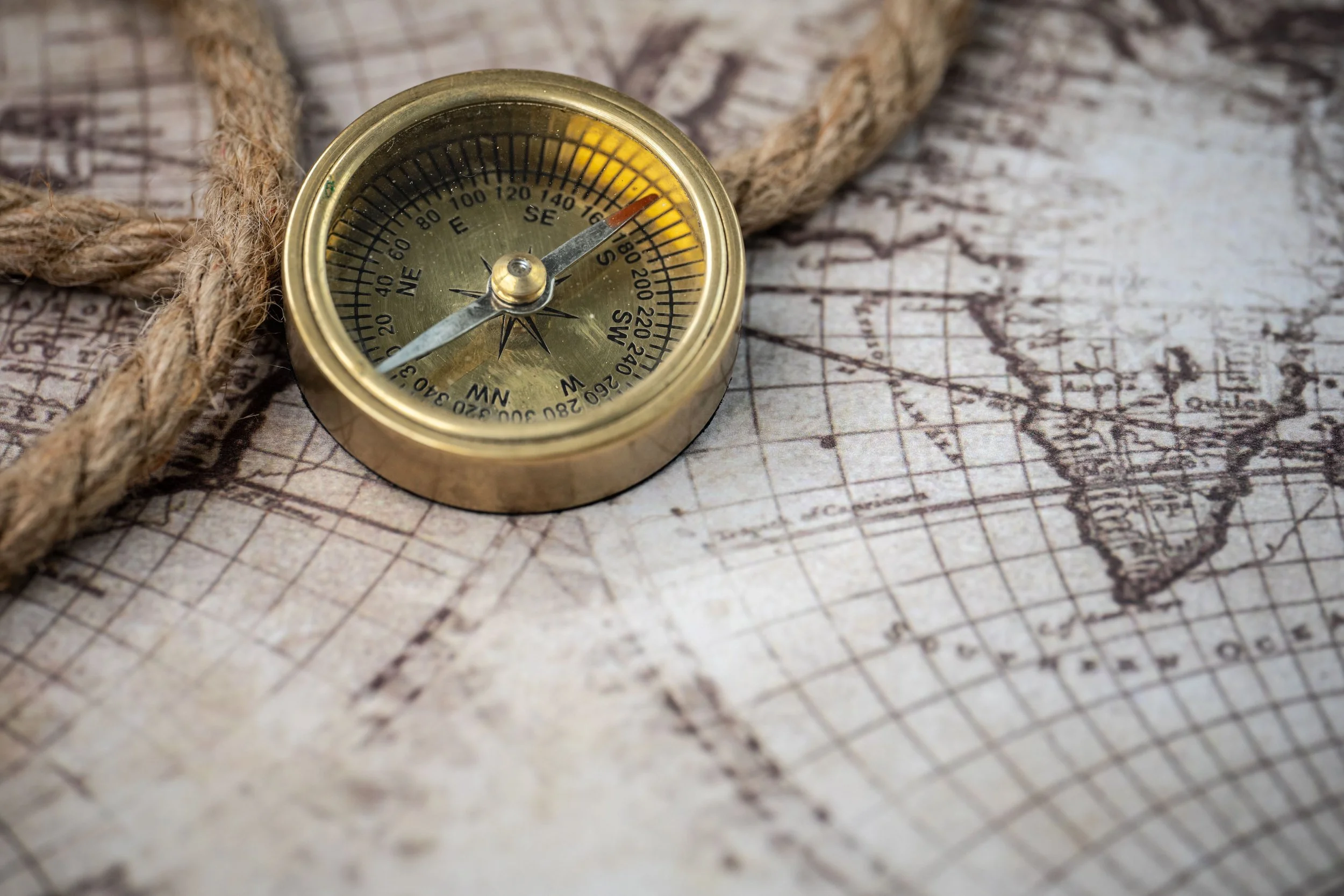 A brass compass rests on a vintage map, symbolizing the journey made possible through nonprofit donations that help children access life-changing summer camp experiences.