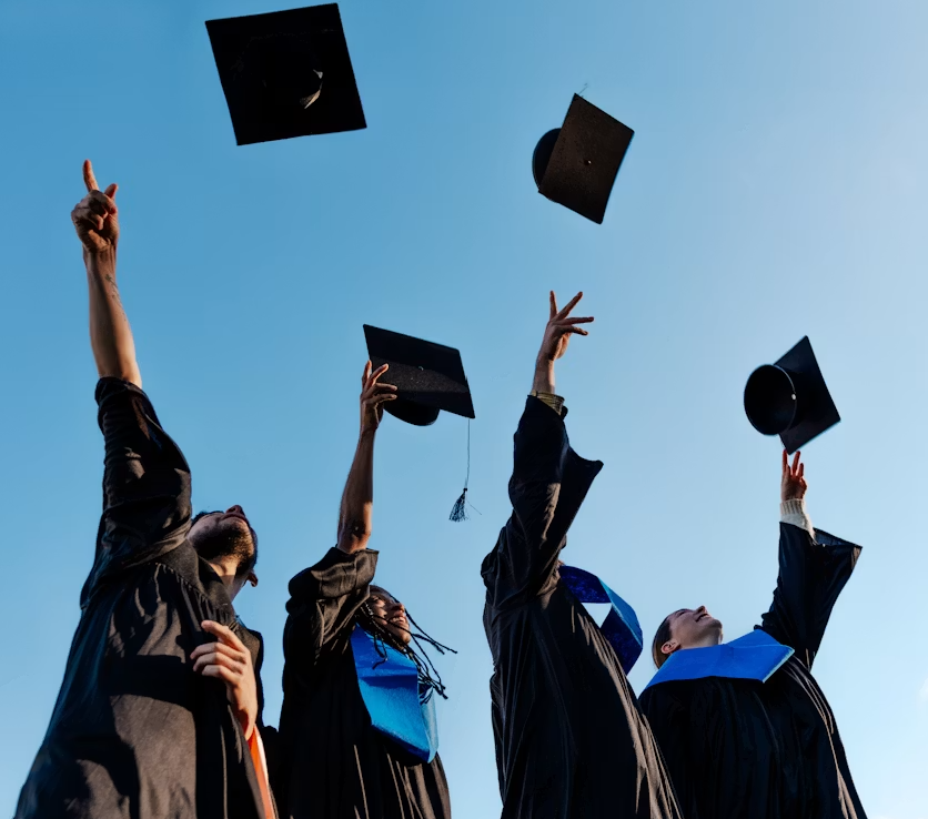 Graduates in caps and gowns tossing their caps into the sky during a graduation ceremony
