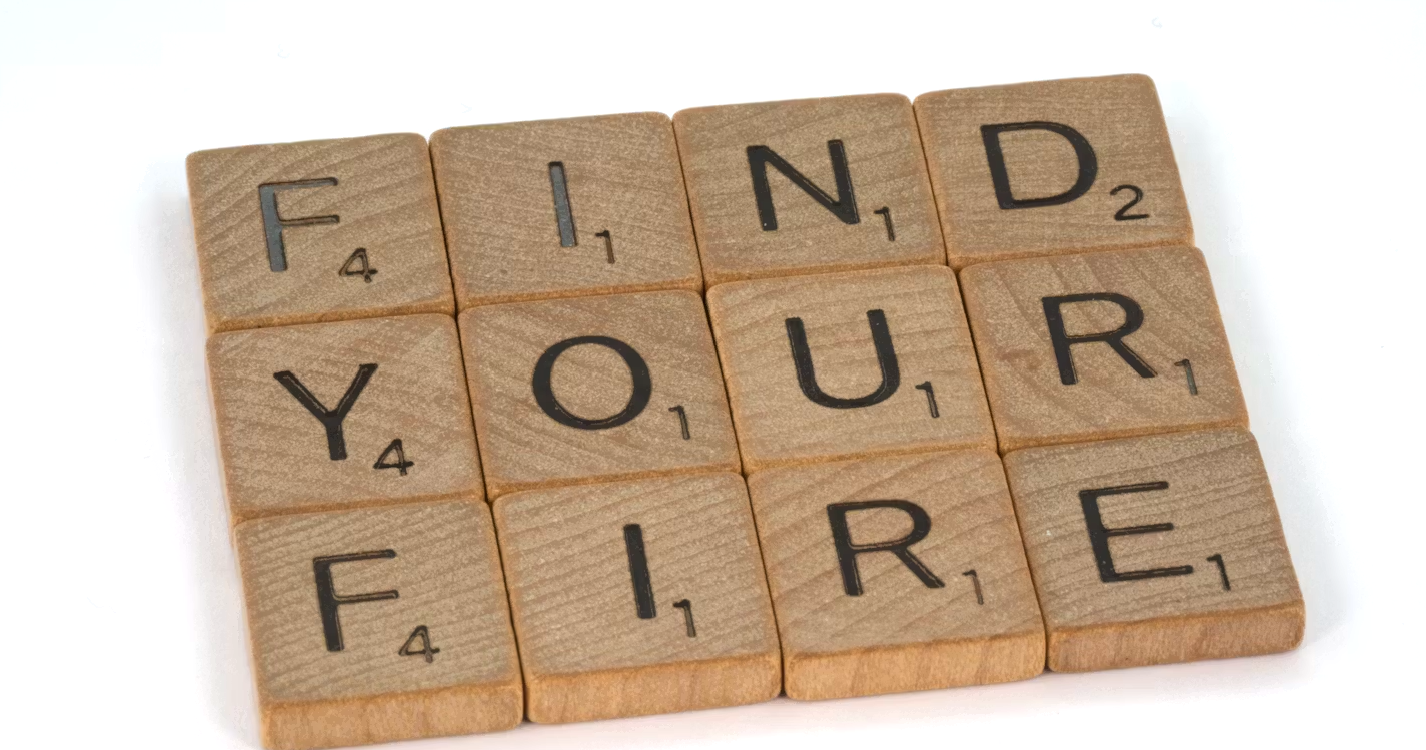Scrabble tiles spelling out "FIND YOUR FIRE" on a white background.