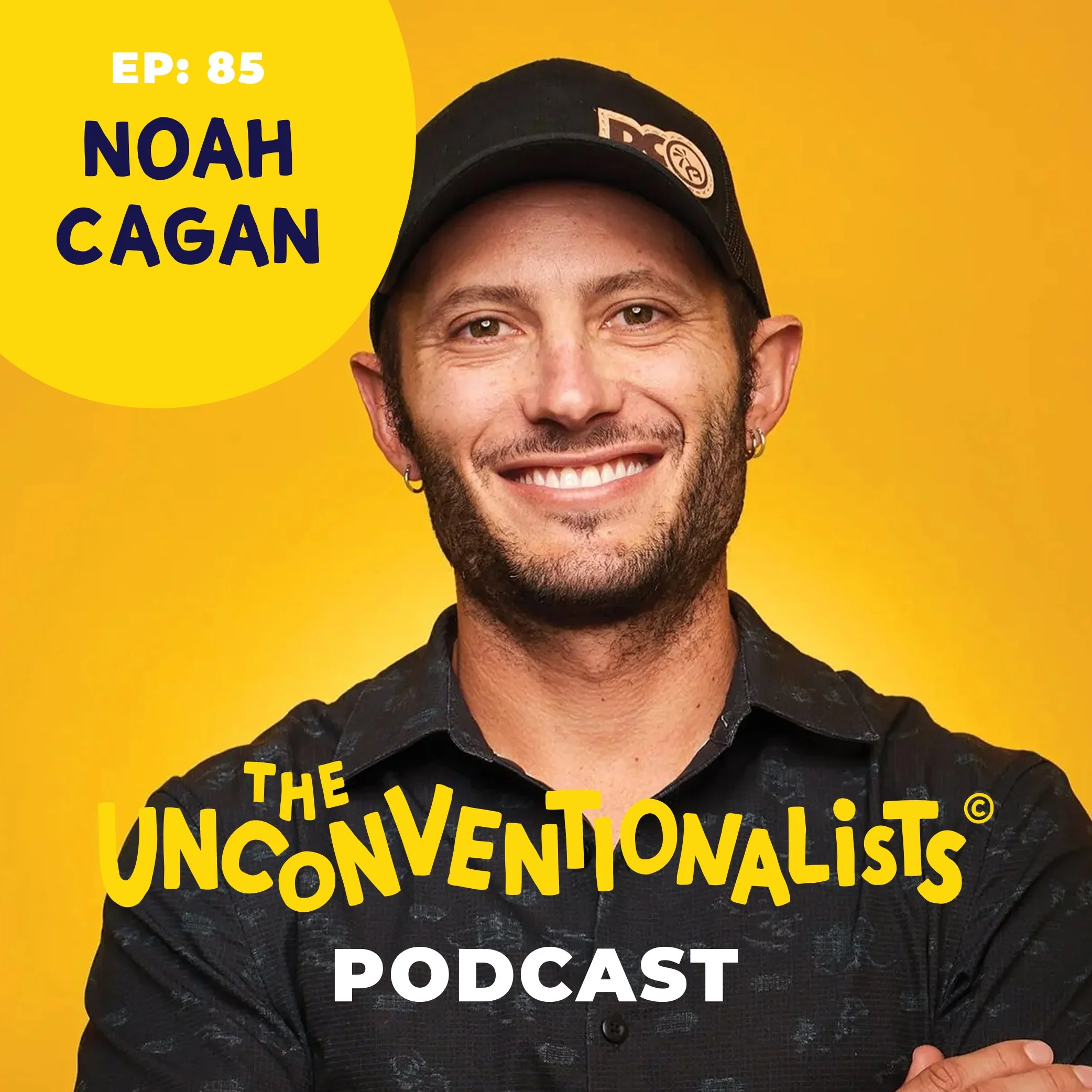 A person with a beard, with a small part of their face and hand visible, wearing a black cap and a black shirt with white patterns, sitting against a yellow background. The person is smiling, and there is text overlaying the image that reads, 'EP: 85 NOAH CAGAN THE UNCONVENTIONALIST PODCAST'.